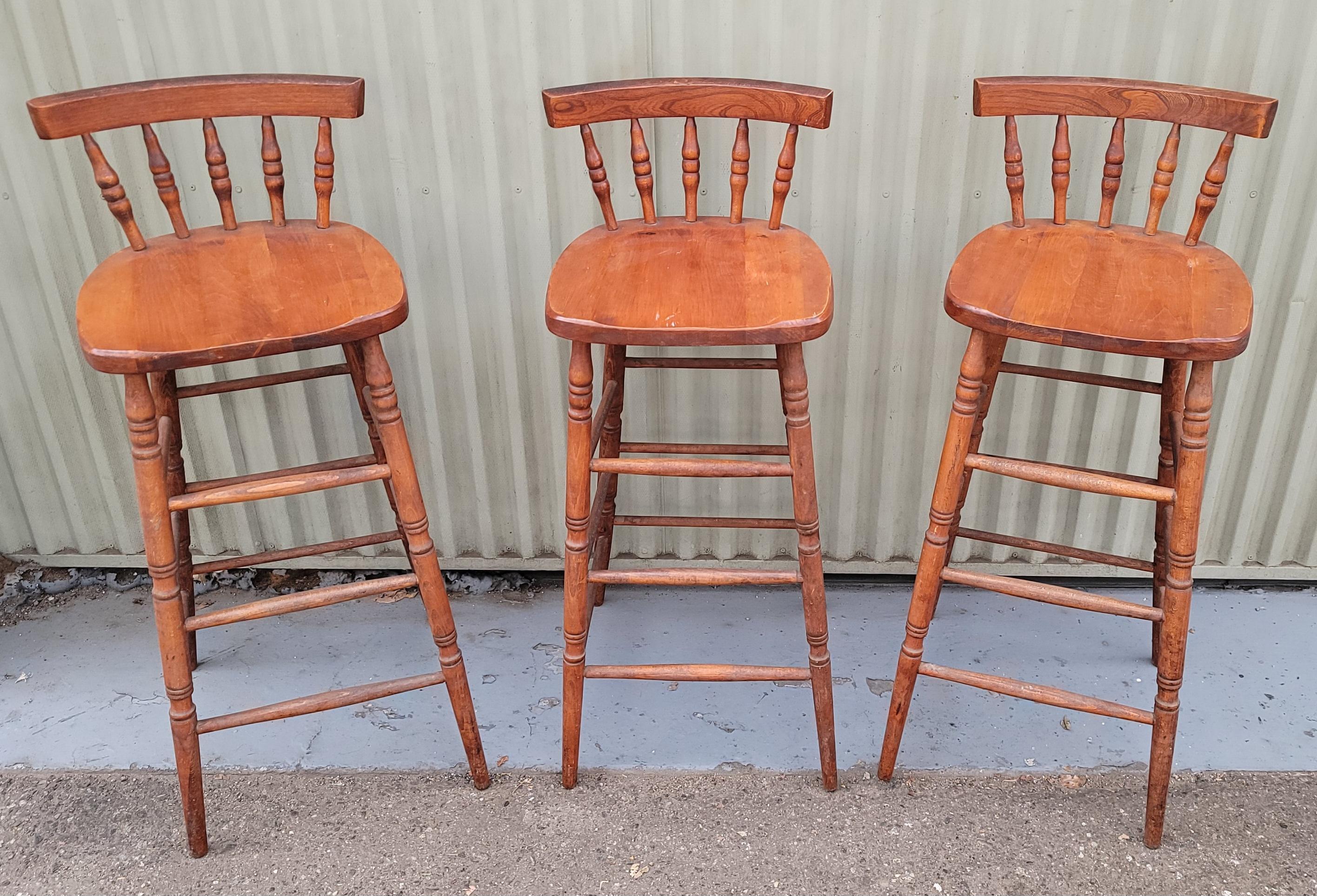 Set of four matching high back bar stools with spindle backs. The construction is very good and sturdy. Natural patina.