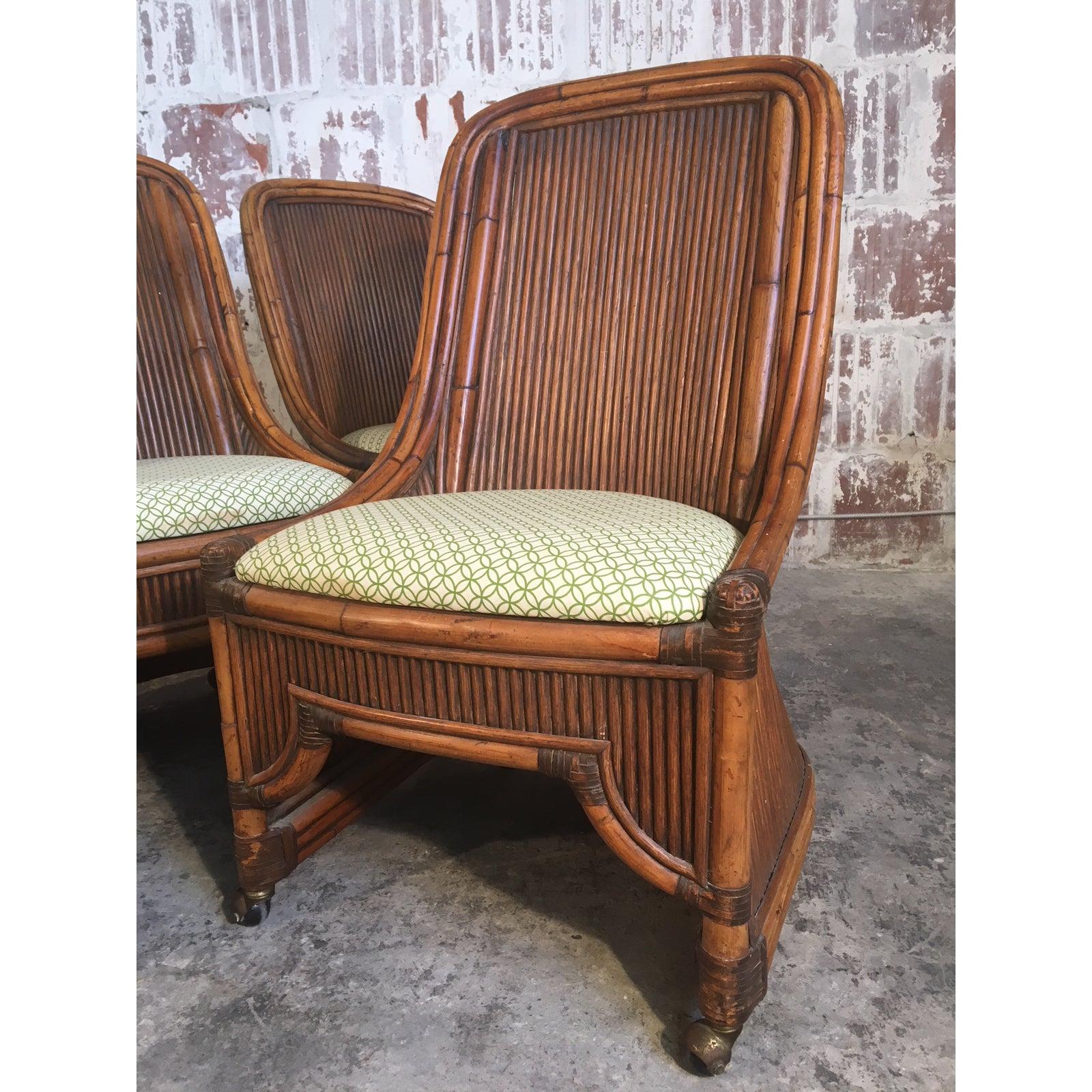 Set of 4 rattan dining chairs feature high back bamboo framework and caster wheels. Very good vintage condition with very minor signs of age appropriate wear. Upholstery free of stains or wear.