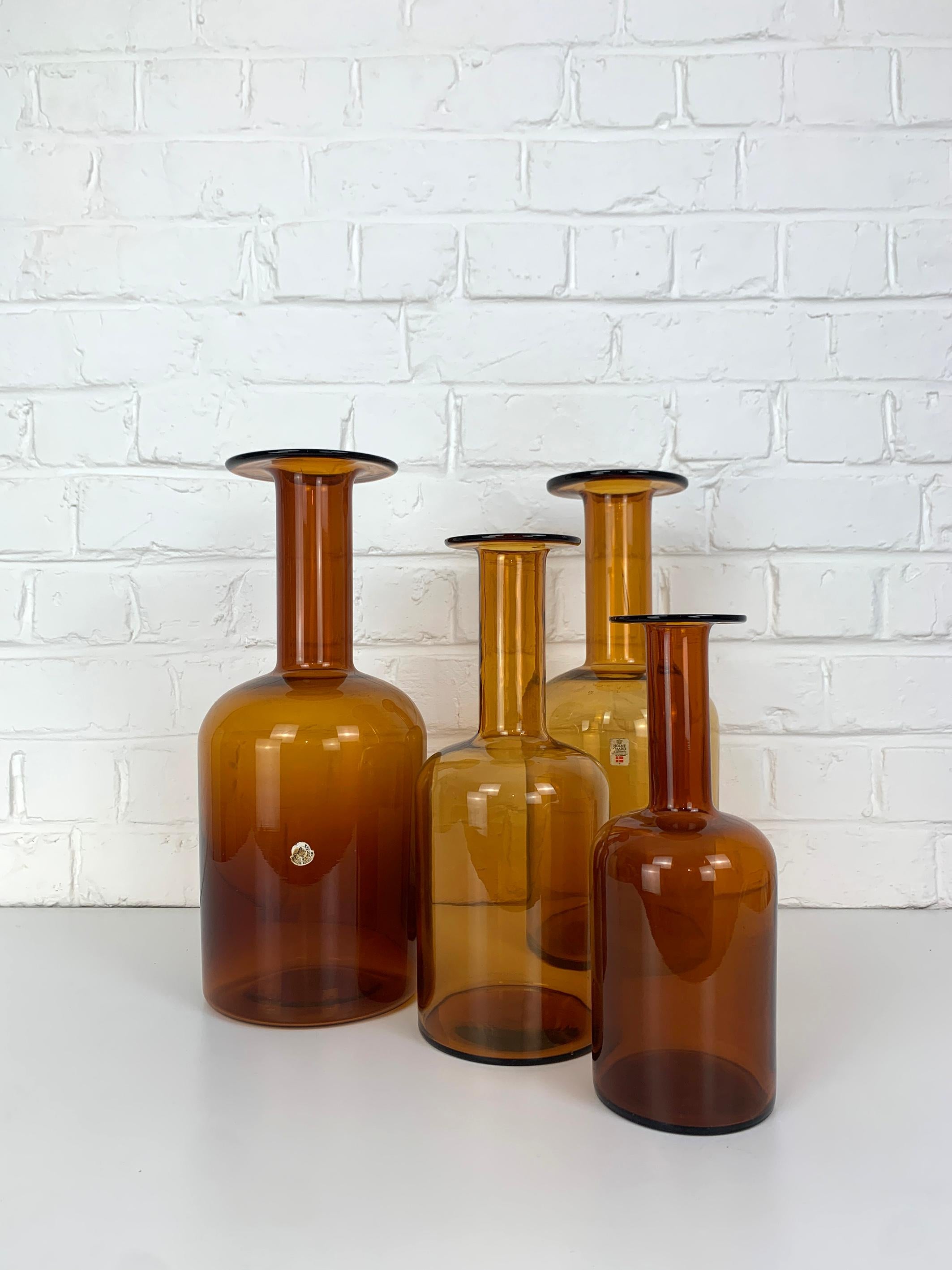 Satz von vier bernsteinfarbenen Holmegaard Gulv-Vasen von Otto Brauer aus der Jahrhundertmitte. 

Diese typisch dänischen modernen Glasflaschenvasen wurden in den 1950er oder 1960er Jahren von Kastrup Holmegaard in Dänemark hergestellt. Zwei der