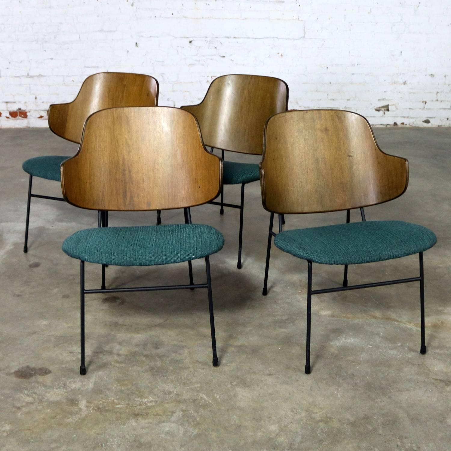 Incredible set of four Scandinavian Mid-Century Modern Ib Kofod-Larsen Penguin chairs. These chairs have a black iron rod frame, walnut molded plywood backs and turquoise tweed upholstered seats. They are in fabulous ready to use condition with new