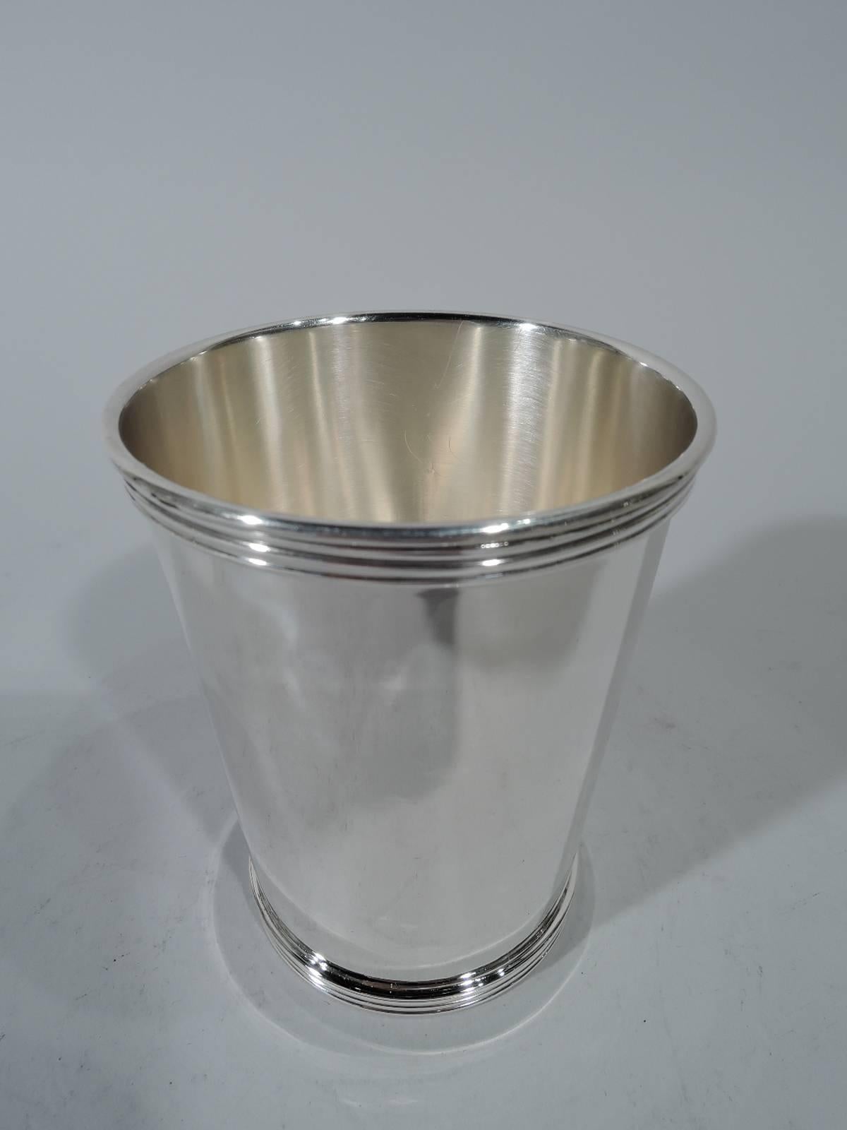 Set of four sterling silver mint juleps. Made by International in Meriden, Conn. Each: Straight and tapering sides, and reeded rim and foot. Hallmark includes no. P699. Total weight: 16.4 troy ounces.