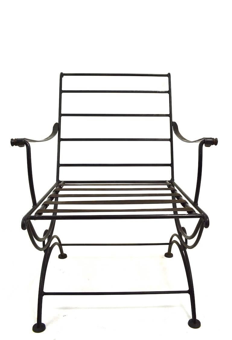 Stylish set of four matching indoor/ outdoor lounge chairs, attributed to the Woodard Furniture Company. These chairs are in very good condition, free of bends, welds or repairs, they are missing the cushions, as shown. Wrought iron frames, vinyl