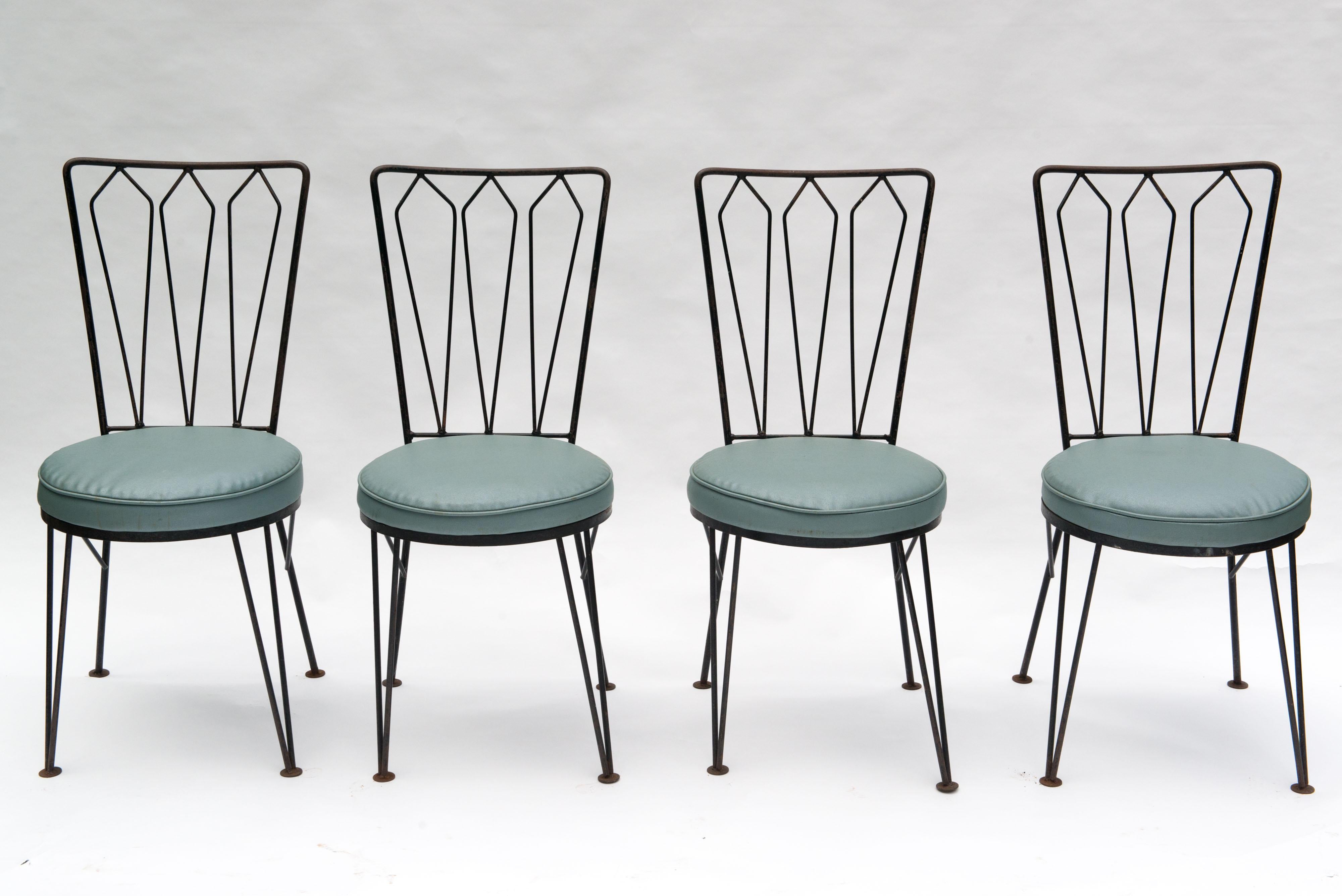 This set of Mid-Century Modern wrought iron dining chairs has the look and high quality construction of Salterini but are made by the Woodard group. Woodard was a high end company in the 1950s. The light blue vinyl seats are original and look good.