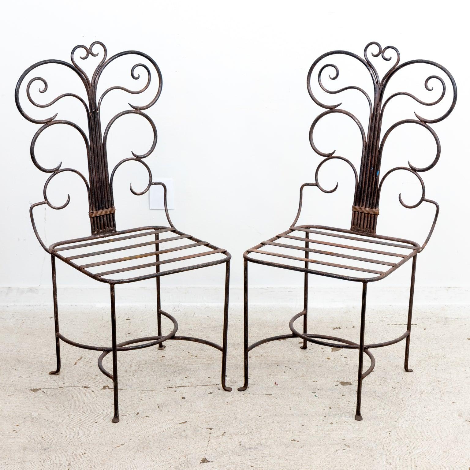 Set of four wrought iron scroll back chairs in the French style with 
straight backs designed with central support, branching out in swooping 
arch forms. The seats feature an open iron slat design ready to support a
 loose or fixed cushion.