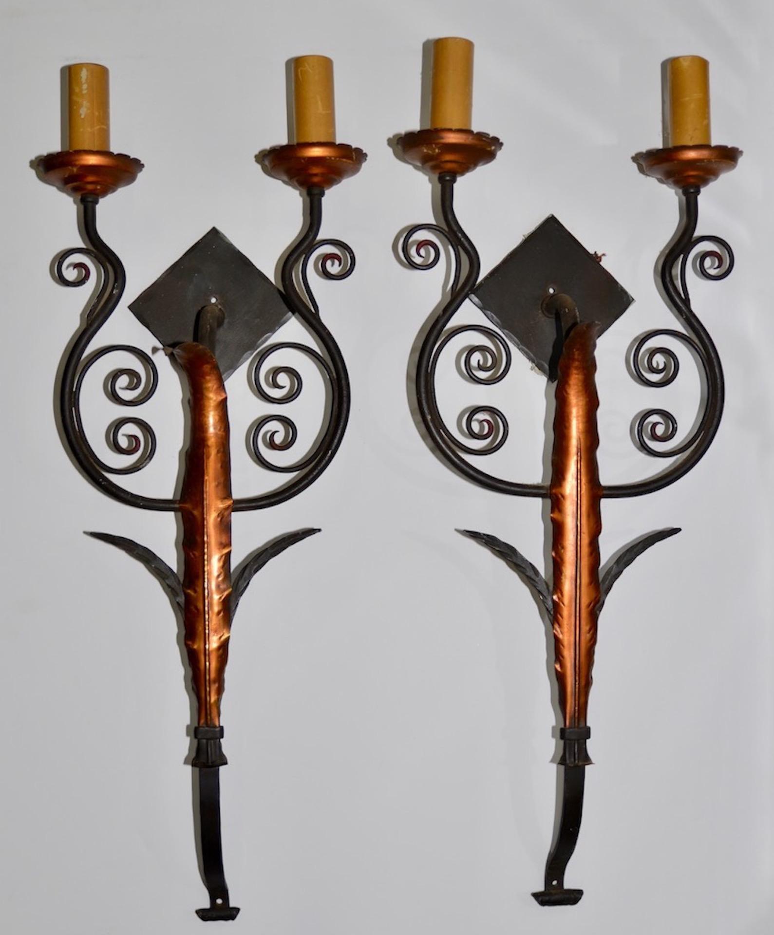 Set of four iron and sheet metal wall sconces, circa 1920s

Fantastic set of four matching wall sconces. Each sconce shows an elegant long leaf with a faux copper finish. Each sconce was two sockets.

Each sconce measures 30