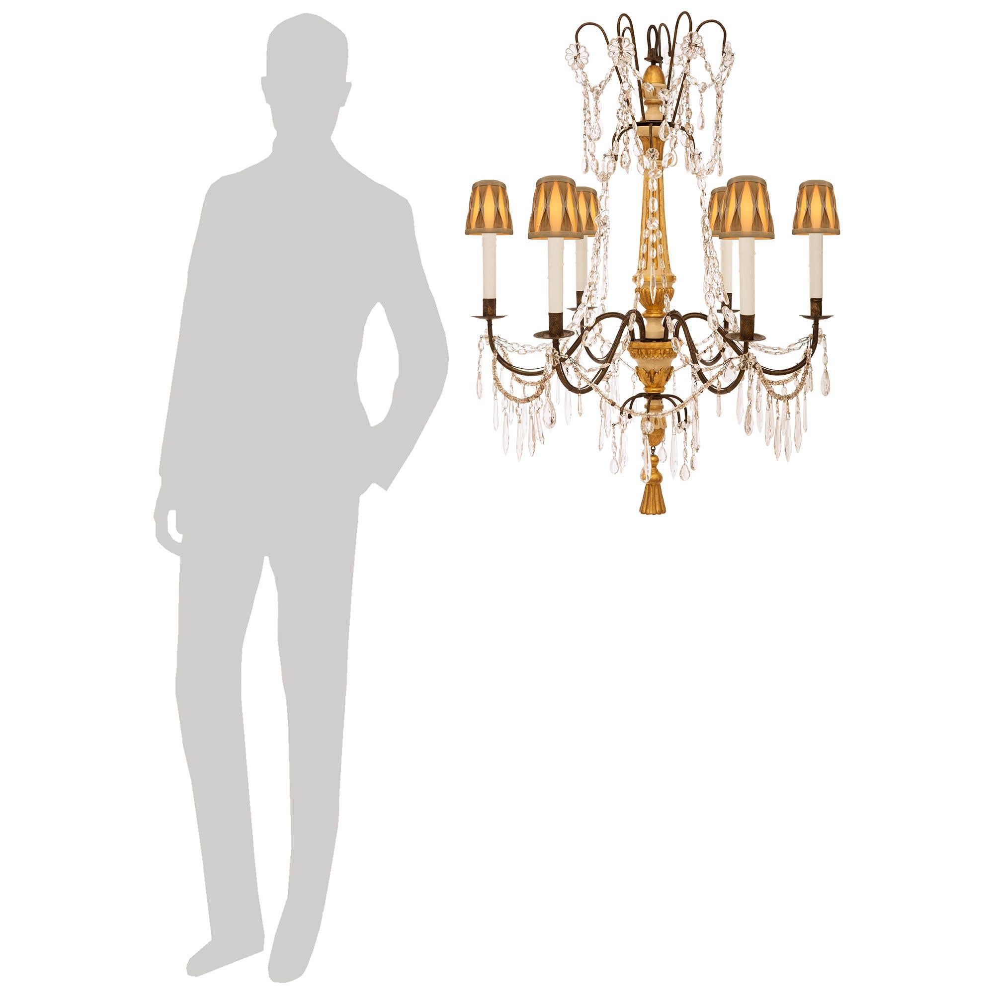 A lovely and most decorative set of four Italian early 19th century Genovese st. Crystal, patinated Wood, Giltwood, and Wrought Iron chandeliers. Each truly stunning six light chandelier is centered by a  carved Giltwood tassel bottom finial hanging