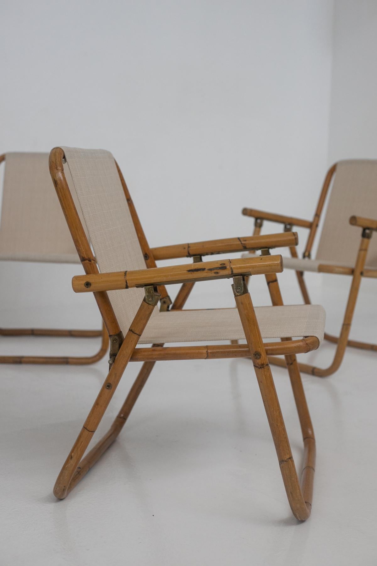 Set of four Italian chairs from the 1950s. The set is made of a very beautiful and elegant bamboo wood frame. The seat and backrest are made of a newly restored beige cotton canvas fabric. Note its brass fittings in excellent patina. The chairs are