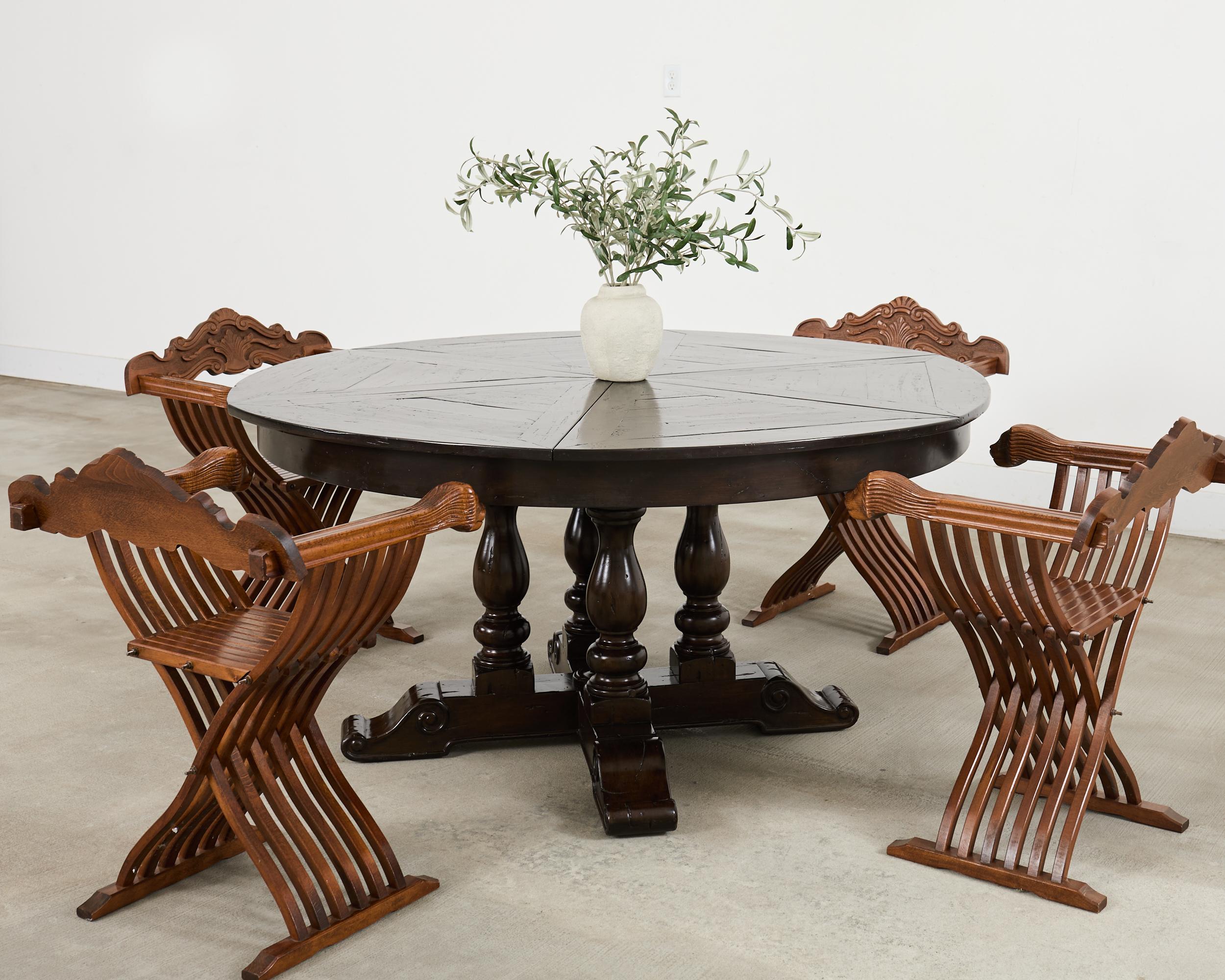 Distintivo set di quattro poltrone Savonarola intagliate in noce in stile italiano Florentine del XX secolo. Le sedie presentano una struttura pieghevole a forbice in stile Campaigner con gambe a curule di gusto barocco. La sedia scultorea ha