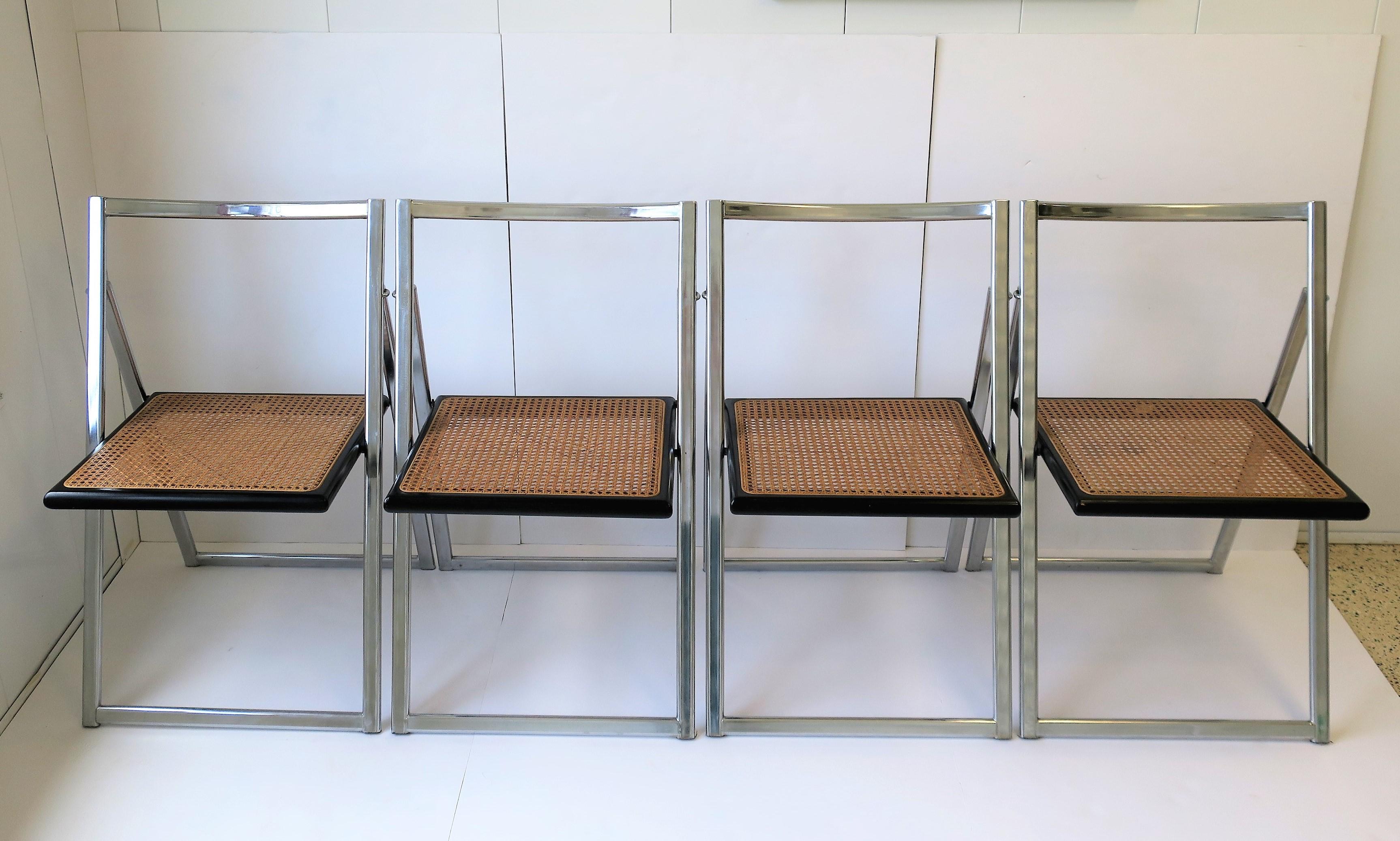 A beautiful set of four (4) Italian Midcentury Modern to Postmodern period chrome, black wood and cane seat folding chairs, attributed to Italian design house Arrben, circa late-1960s - 1970s, Italy. Marked 