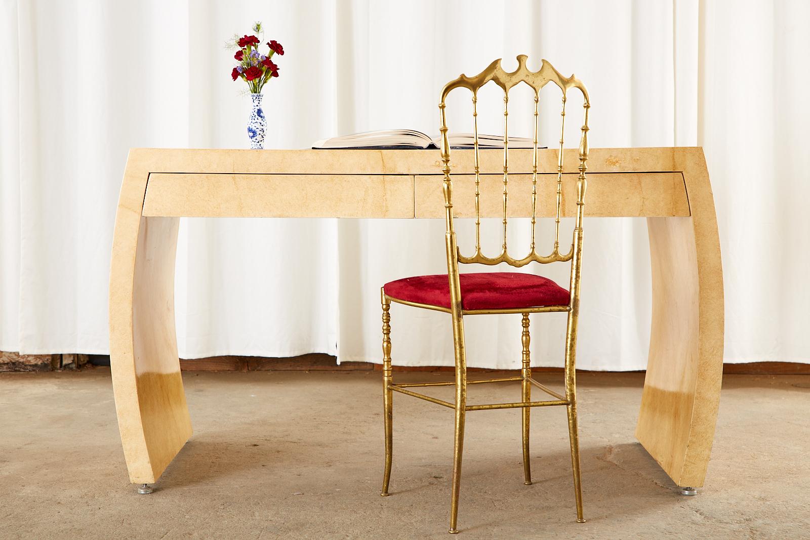 Opulenter Satz von vier italienischen Chiavari-Ballsaalstühlen oder Esszimmerstühlen mit Messingrahmen. Die eleganten Stühle haben dekorativ geformte Kämme mit Spindelrückenleisten. Die Sitzpads sind mit einem weichen Stoff in rotem Samt gepolstert.