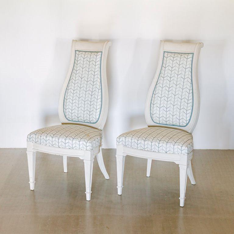 A set of four Italian chalky white painted upholstered dining chairs with harp shaped back, carved legs and sabre back legs 1960s, upholstered in a printed linen.

Additional information:
Dimensions: 59 D x 55 W x 112 H cm.