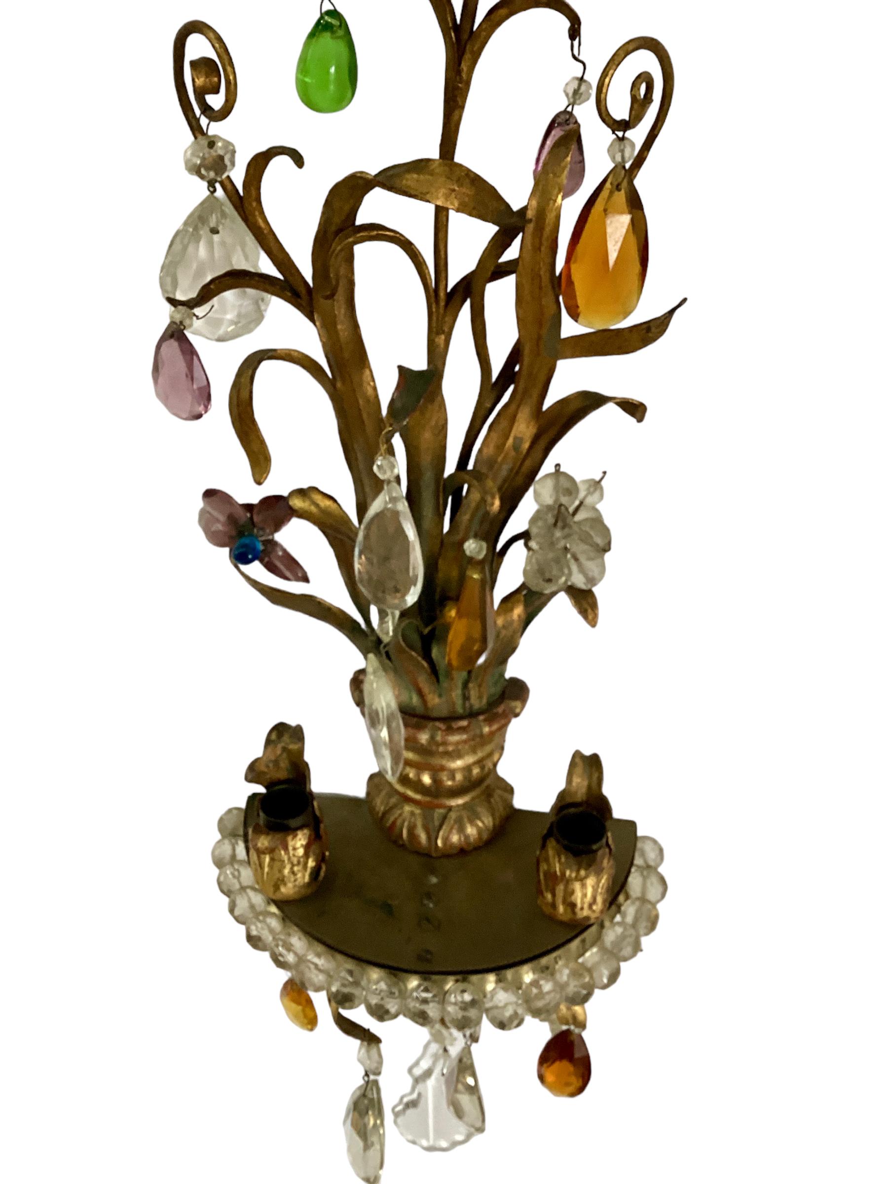 A gorgeous Set of Four Italian Giltwood and Gilt Metal Sconces with Colored Crystals. Two light candle sconces that can easily be wired for electricity. Foliate design with various colors of crystals intermingled with clear cut crystals. 