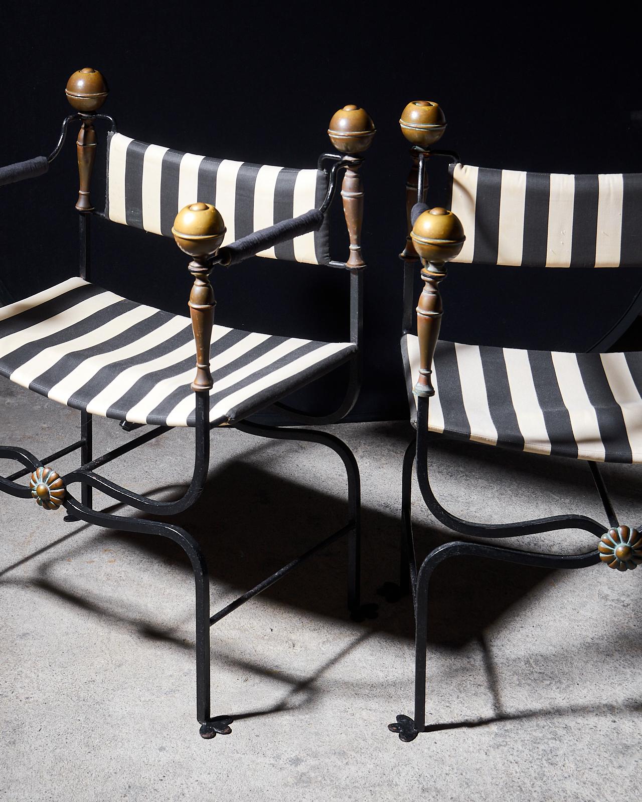 Stunning set of four Italian Savonarola armchairs or Dante chairs hand-crafted from iron. The frames are made in a campaign style featuring curule legs that end with whimsical bird feet and bronze mounts with large patinated brass finials.