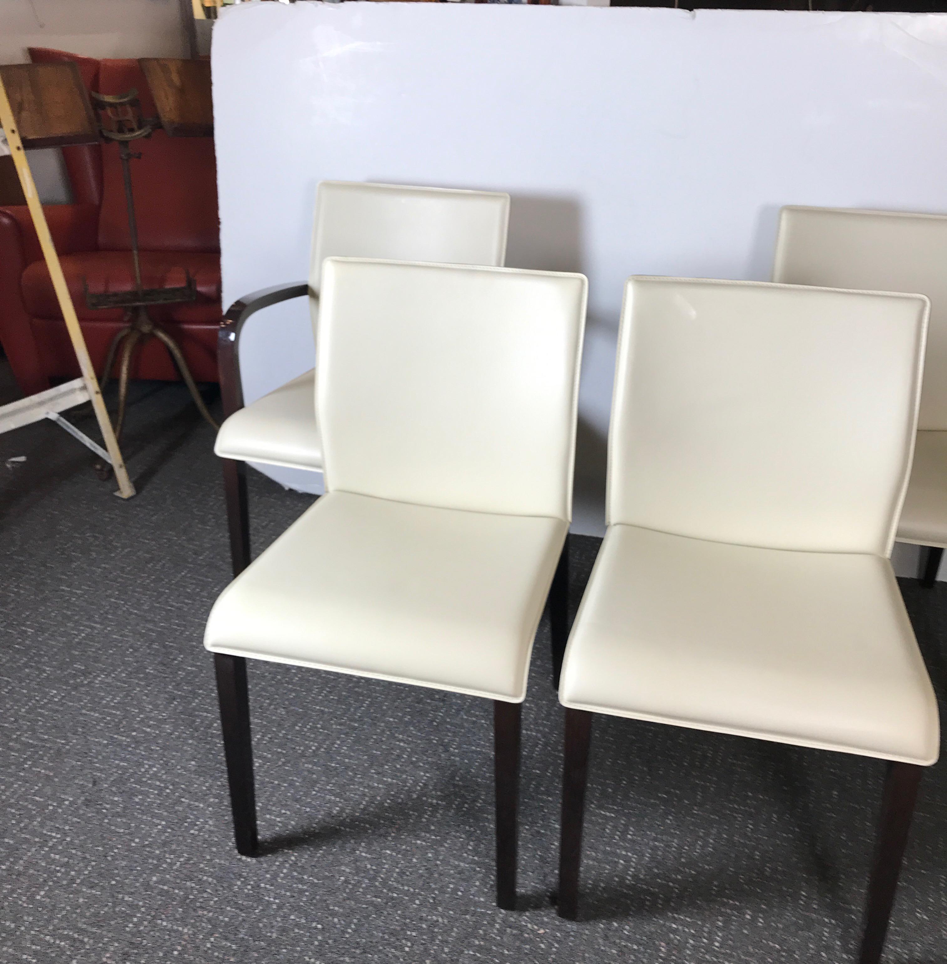 A set of four Italian leather chairs with high gloss finish frames. The vanilla leather back and seats with polished and clear lacquered wood frames, 2 armchairs, 2 side chairs. Marked on the underside Italy.