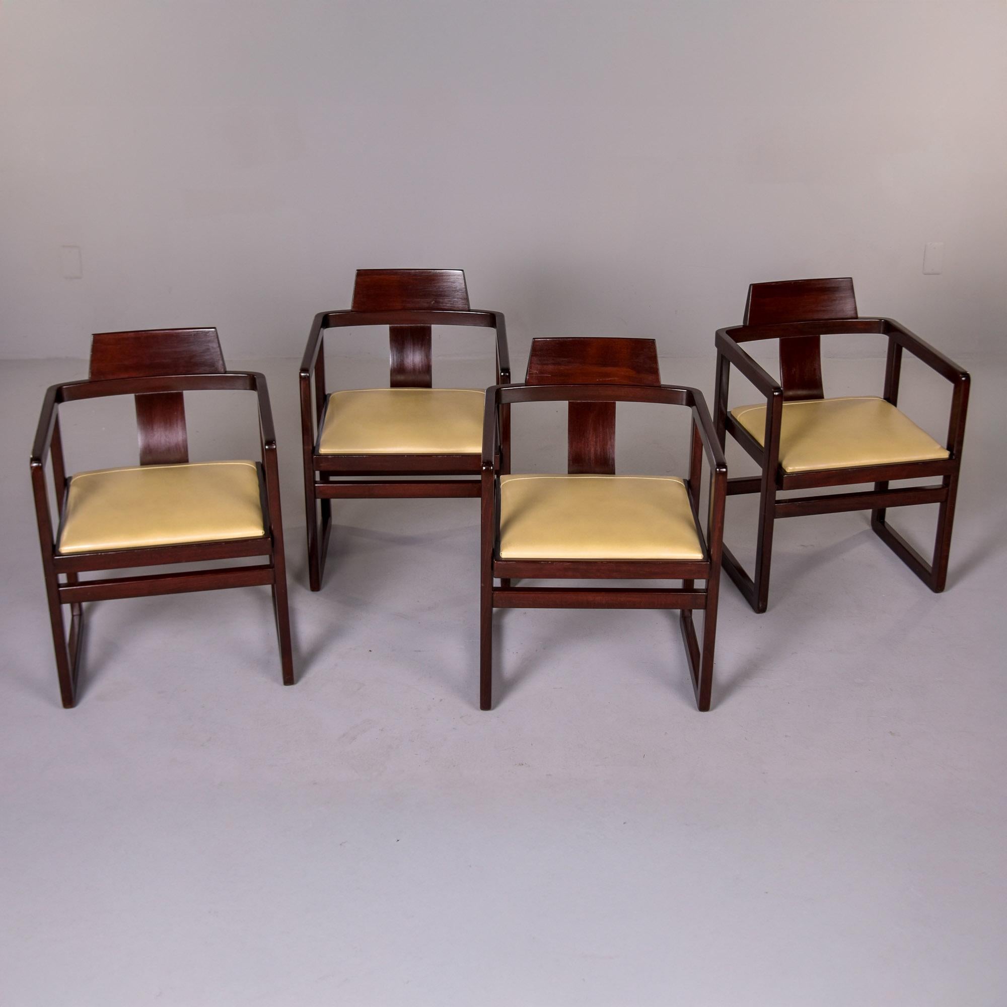 Trovato in Italia, questo set di quattro poltrone di ispirazione asiatica risale agli anni '60. I telai sono in legno tinto scuro di specie sconosciuta e hanno una forma ariosa e squadrata con uno schienale a forma di T più ampio e contrastante.