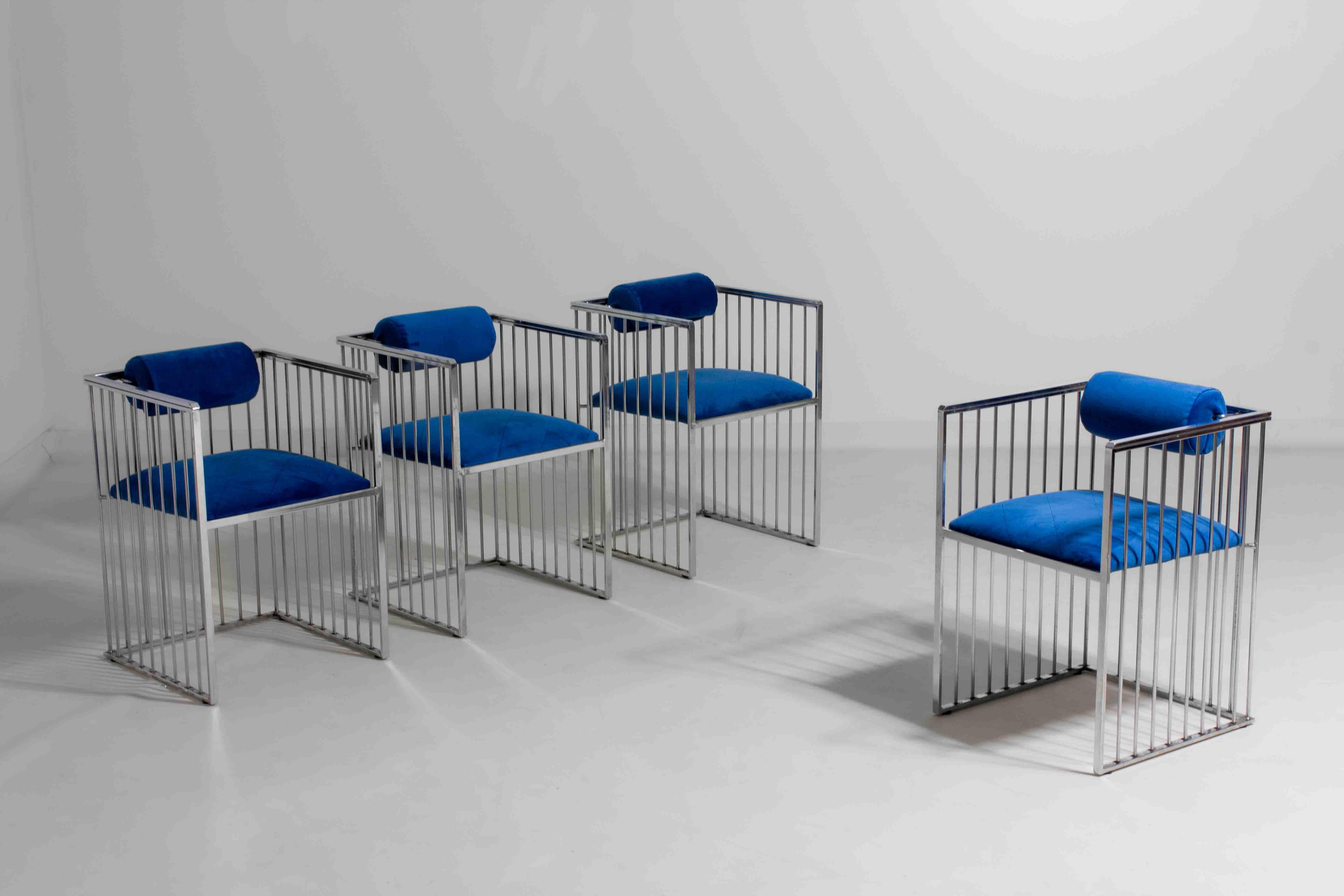 Bold and sculptural set of chrome-framed art deco style chairs from the 1970s. The vertical bar design gives them a strong architectural feel, while the cobalt blue velvet upholstery with subtle checkered stitching adds a rich, luxurious contrast.