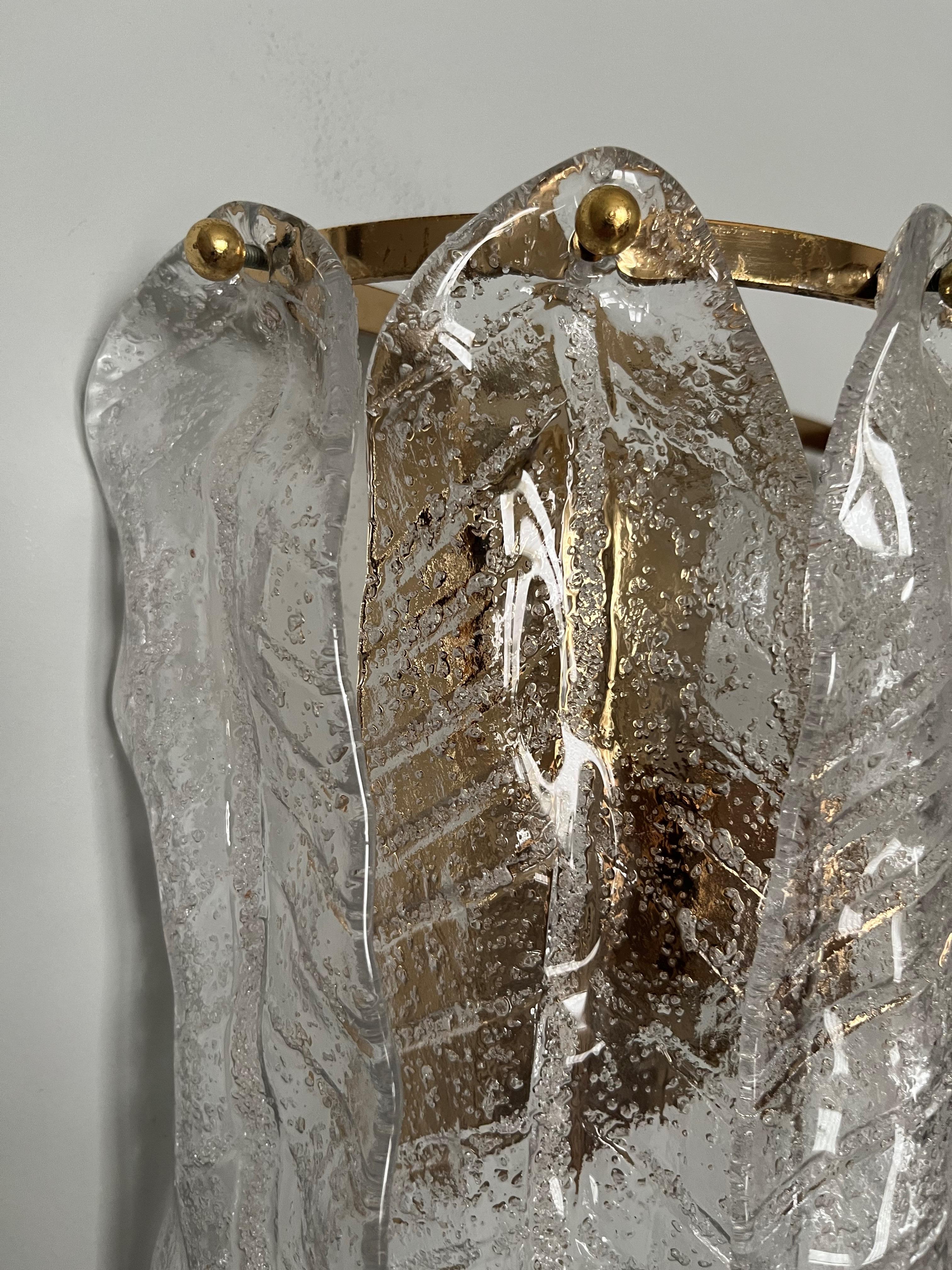 Stunning set of four Italian clear Murano glass leaf Wall Sconces from 1970s. These fixtures were made during the 1970s in Italy.
Each wall sconce is composed by 6 units of Murano glasses and brass structure.
Each sconce is equipped with 2 light