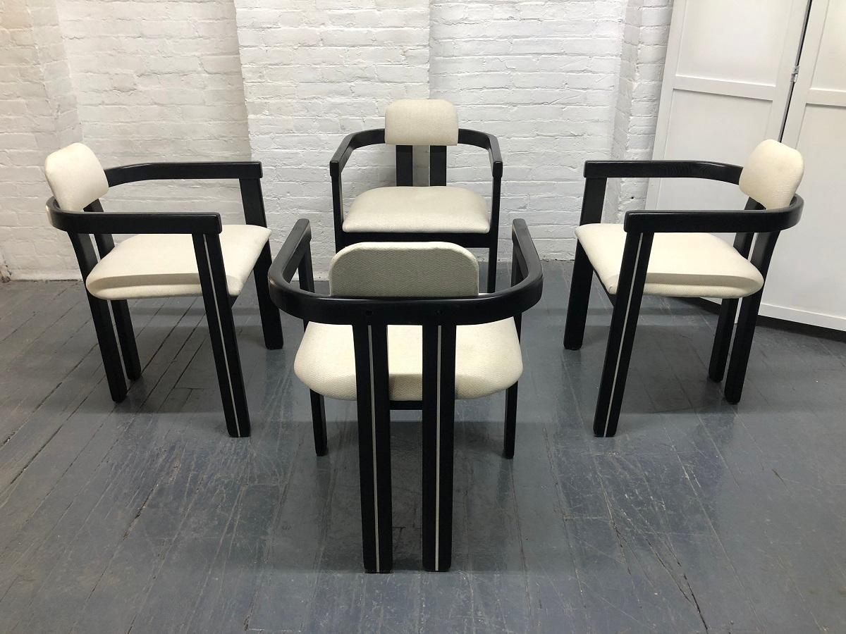 Set of four Italian sculptural dining chairs. The chairs have black lacquered sculptural frames with cushioned seats and backs.