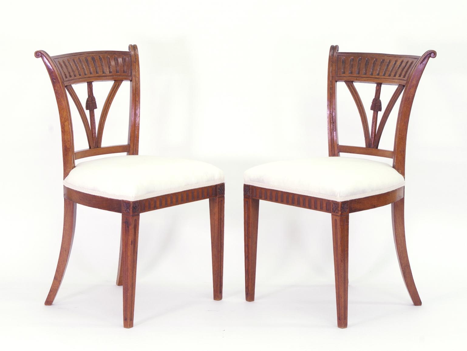 Set of four Italian solid ash side chairs, each with a fluted tablet over the spindle back with carved tassels; the upholstered seats on square tapered and fluted legs.

These delightful chairs have beautiful color and patina. Recently polished