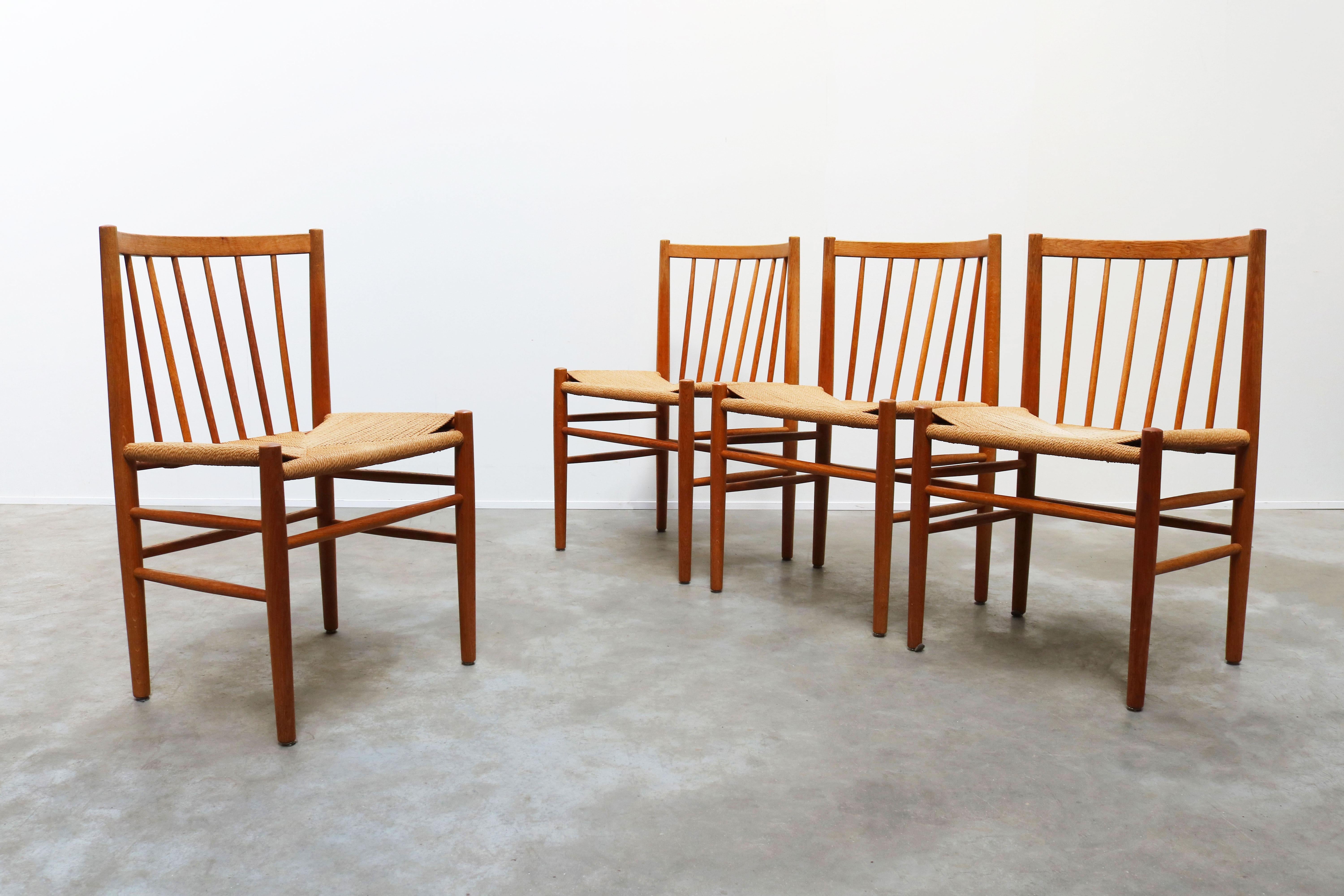 Rare set of four dining chairs model: J80 designed by Jorgen Baekmark for FDM Møbler in the 1950s. The chairs are made out of solid oak with handwoven papercord. Gorgeous Minimalist Shaker style design. The chairs look amazing with the unique curved