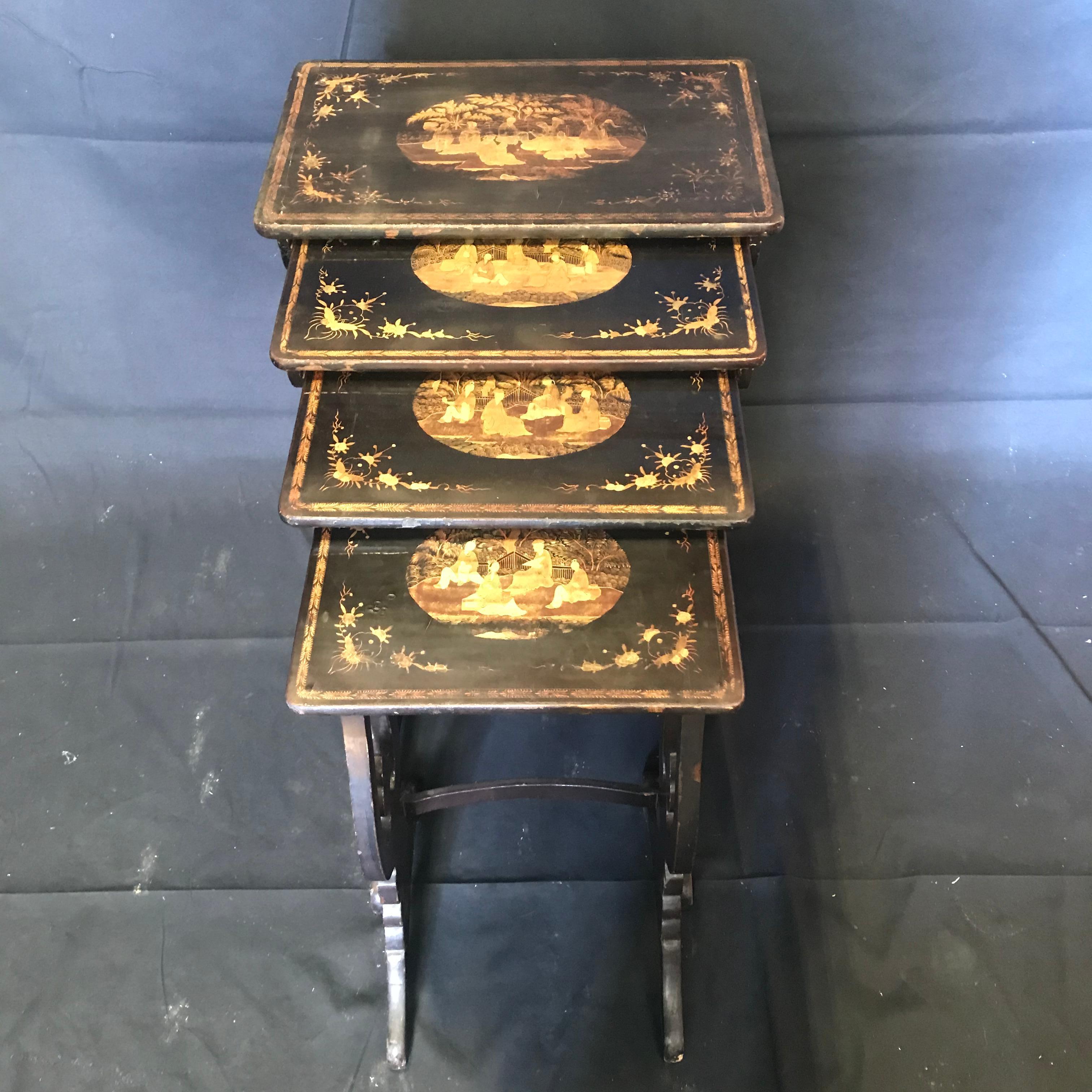 Set of four hand carved Asian style nesting tables featuring an hourglass form design and exquisitely hand painted figural scenes on each tabletop. Each table has a curved spreader and fits perfectly together. Unique chinoiserie design with a fleur