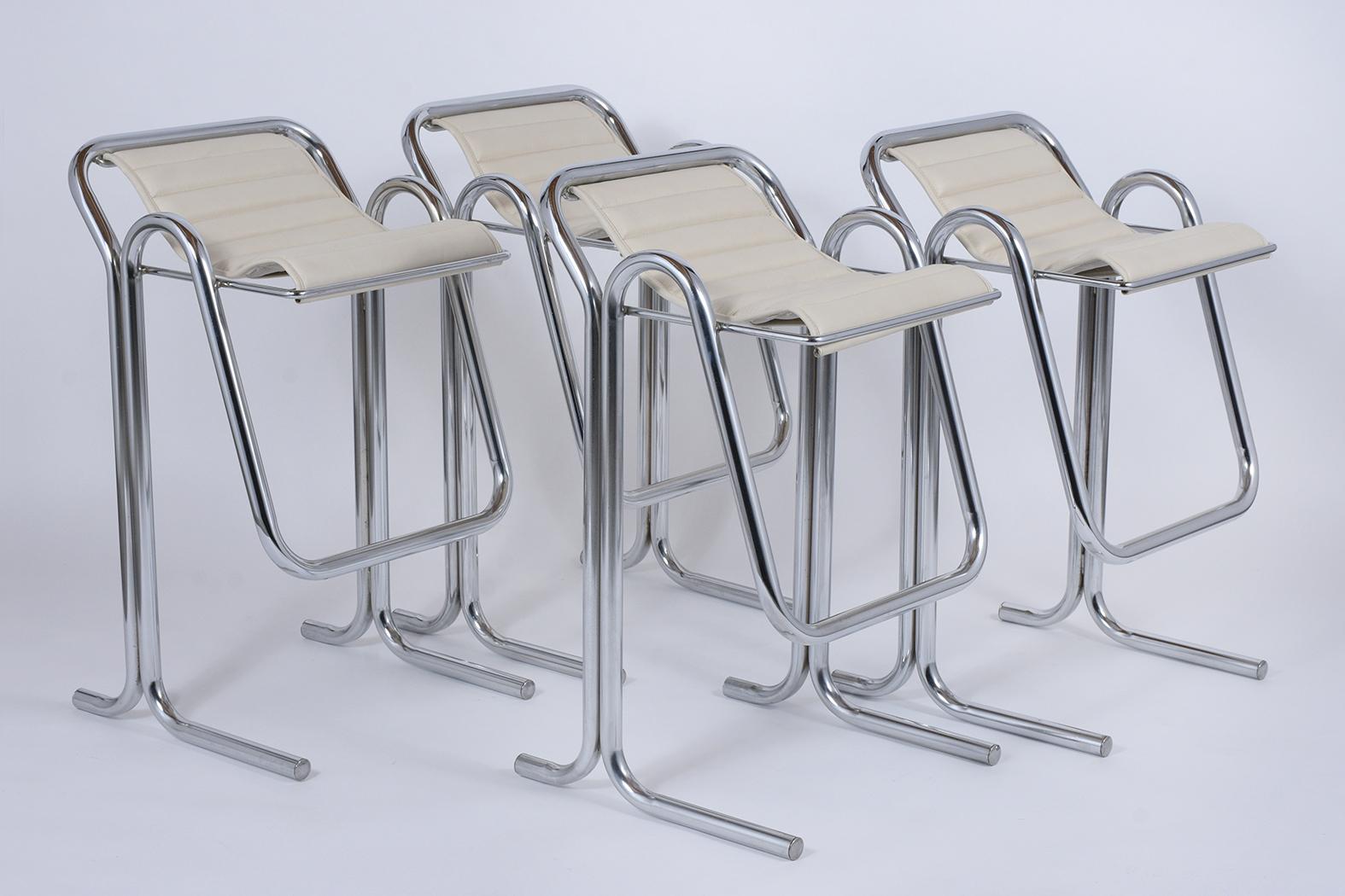 A set of four Mid-Century Modern barstools handcrafted out of steel, these stools are eye-catching and feature a sturdy chrome tubular frame with built-in footrests. The seats come with a channeled design and are newly upholstered in ivory color