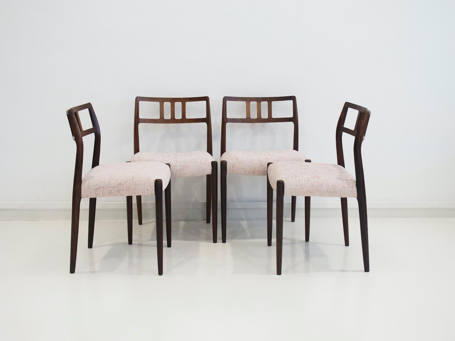 Set of four dining chairs designed by Niels Otto Møller, model 79. Manufactured by J.L. Møbler in Denmark. Frame made of hardwood, seat reupholstered in light pink and white polyester fabric.