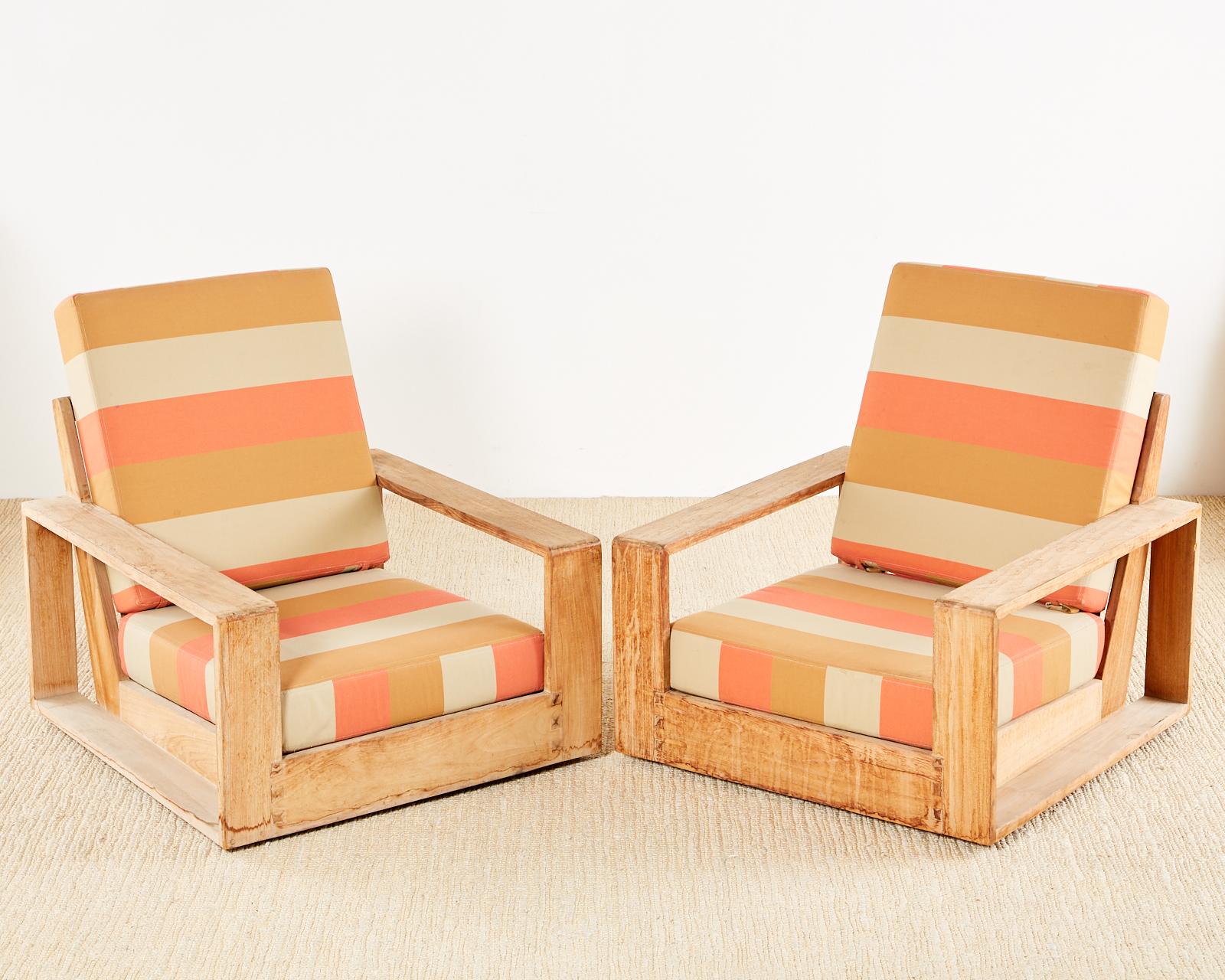 Stylish set of four teak patio poolside lounge chairs designed by John Hutton for Sutherland Furniture. The chairs feature a natural weathered teak finish with bright stripe upholstery in an all weather fabric. Set consists of two generous armchairs