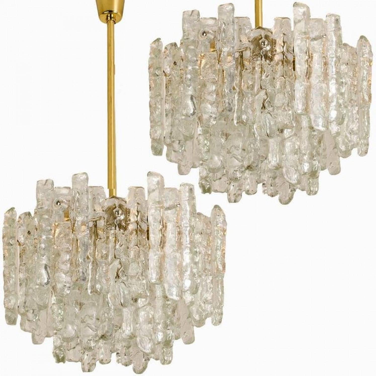 Coppia di bellissimi ed eleganti lampadari moderni in ottone, prodotti da Kalmar Austria negli anni '70. Un design incantevole, realizzato con uno standard molto elevato. Ogni lampadario ha due strati di lastre di vetro massiccio di ghiaccio (18