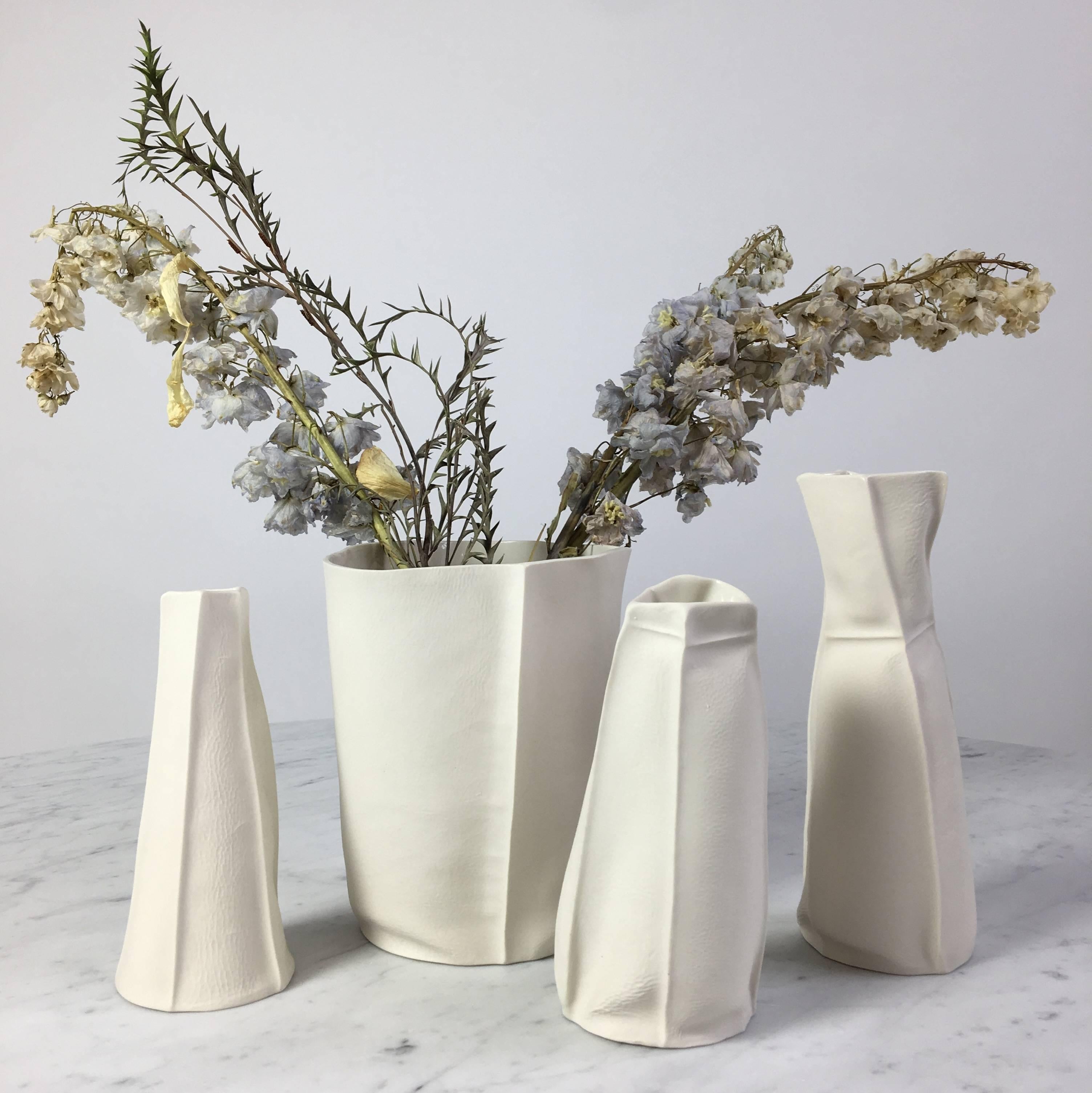 This listing is for a set of four unusual vaseses and vessels from the Kawa Porcelain series designed/made by Souda's Co-Owner, Luft Tanaka. Each piece has been made by casting liquid porcelain into a molds made entirely of leather. This