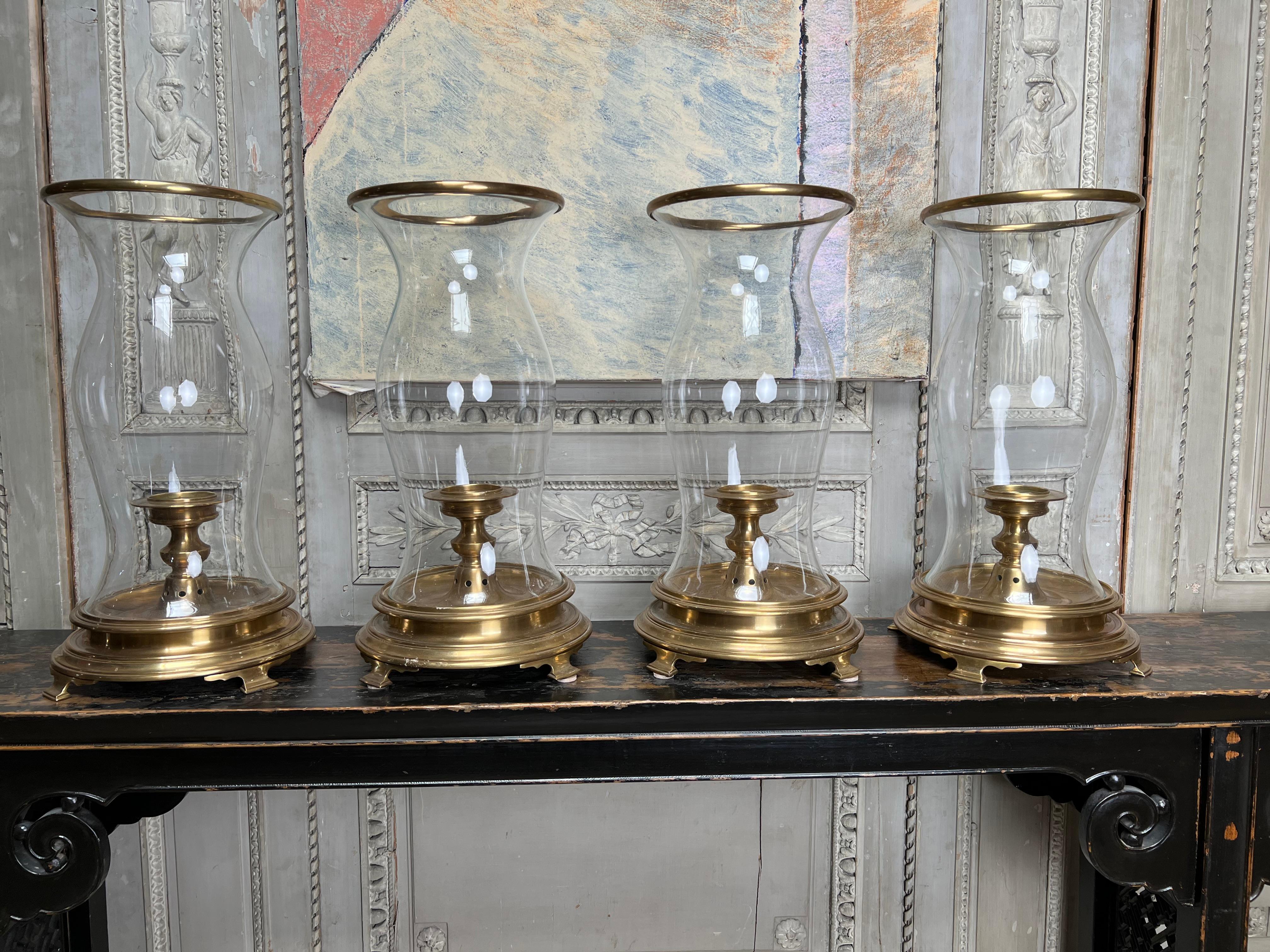 A set of four very large brass and glass hurricane candle holders from the 1970's by Chapman. 
They are in very good condition and have a brass trim around the top to help protect the glass.
 