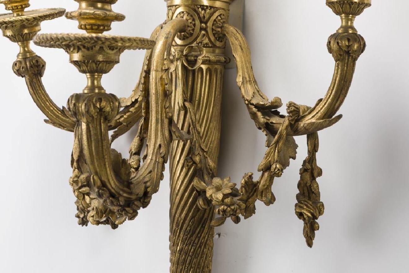 Exquisite large set of four French Louis XVI style ormolu sconces. (A)
Late 19th-early 20th century 
Each three-light sconce is surmounted with a tied ribbon, above a fine quiver of arrows central shaft, issuing three acanthus inspired arms with