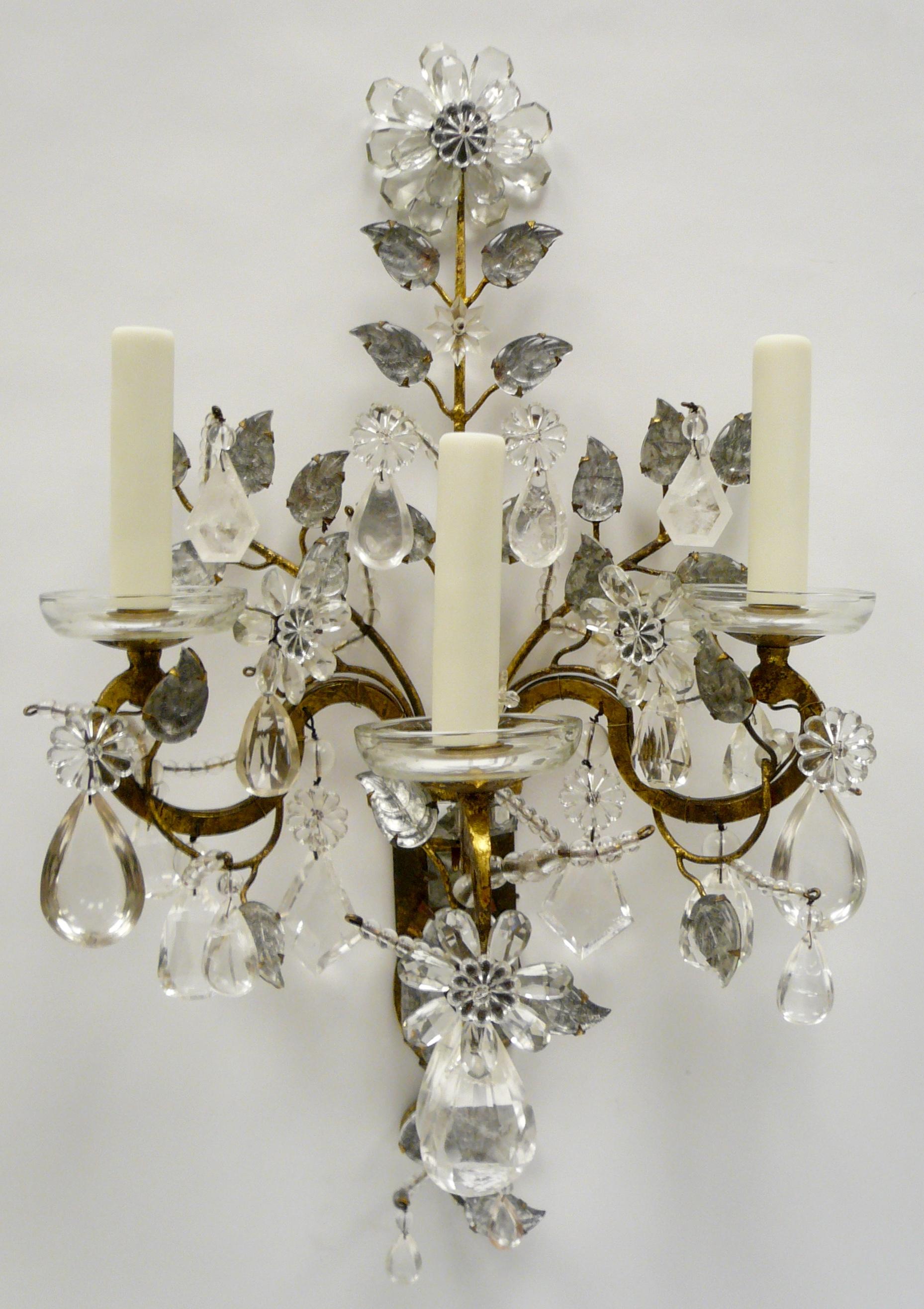 This amazing set of four sconces feature central carved rock crystal vases richly decorated with floral and foliate motifs, and rock crystal drops. Founded in 1860, Maison Baguès is the last word in French classic handmade lighting.