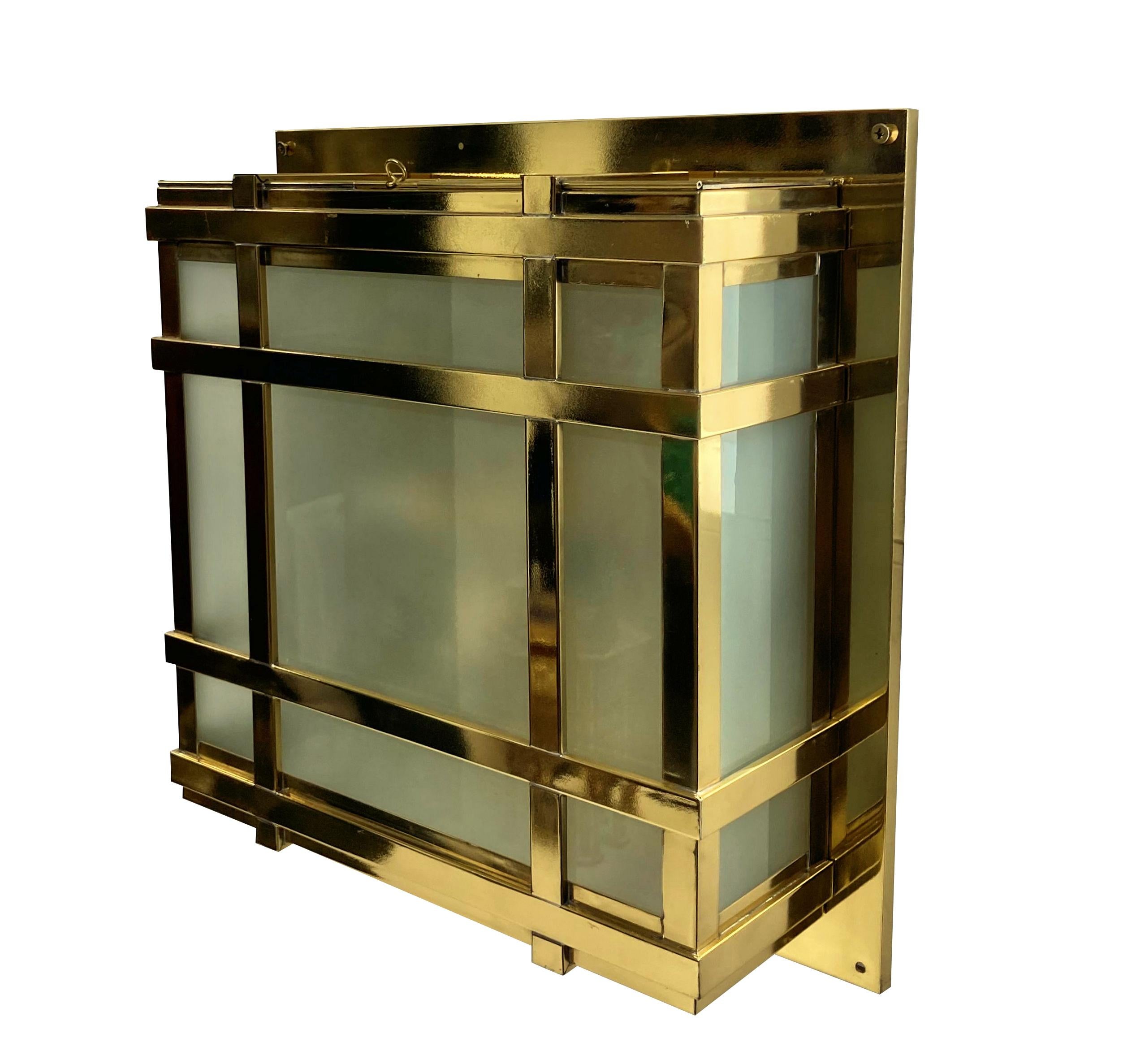 A set of four large American Modernist wall lights in lacquered brass, with opaque glass panels. Each with a door and provision for four lights inside each.