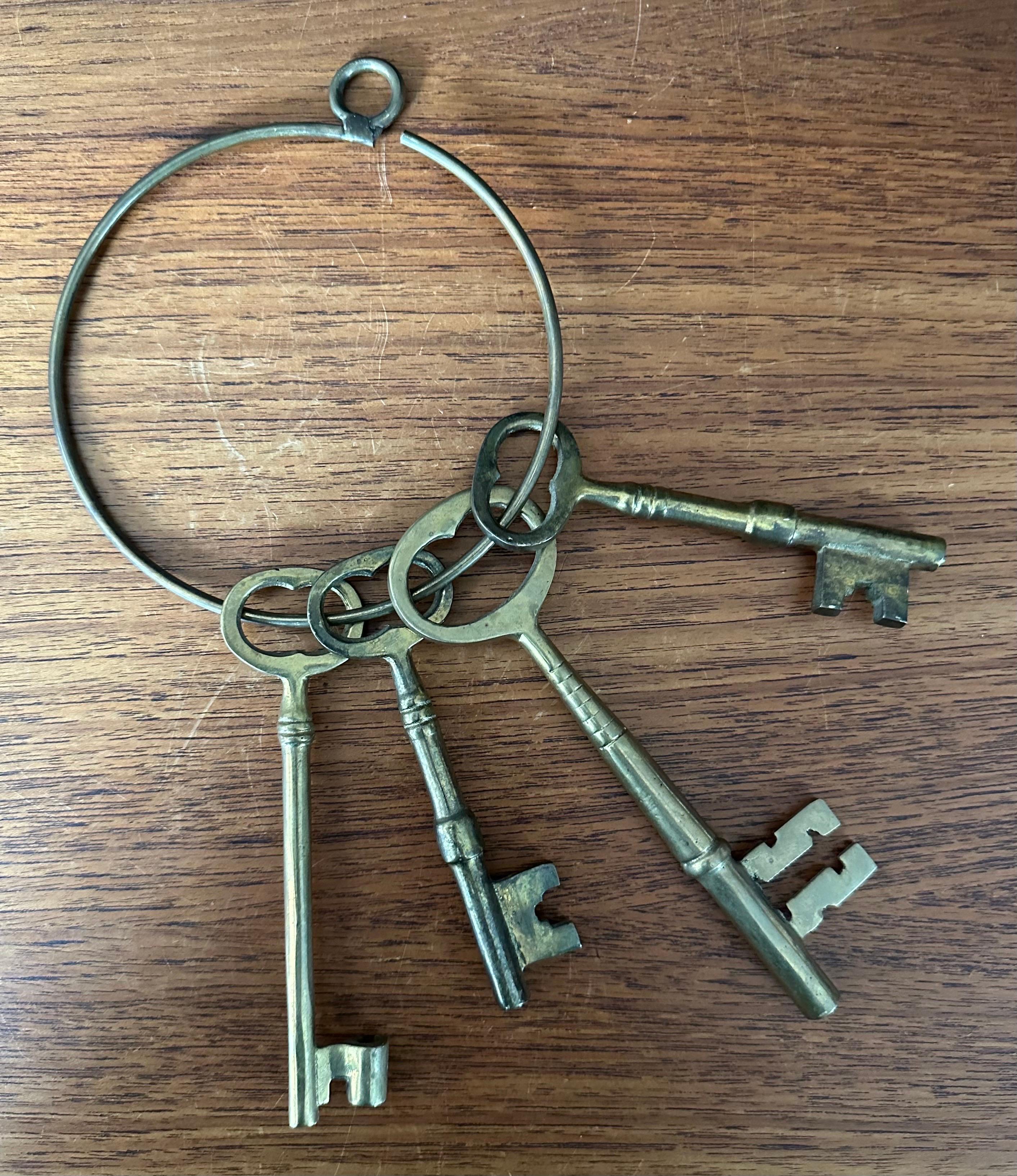 Set of four large vintage skeleton keys on a ring, circa 1950s. The set is in good vintage condition with a nice patina and measures 6.75