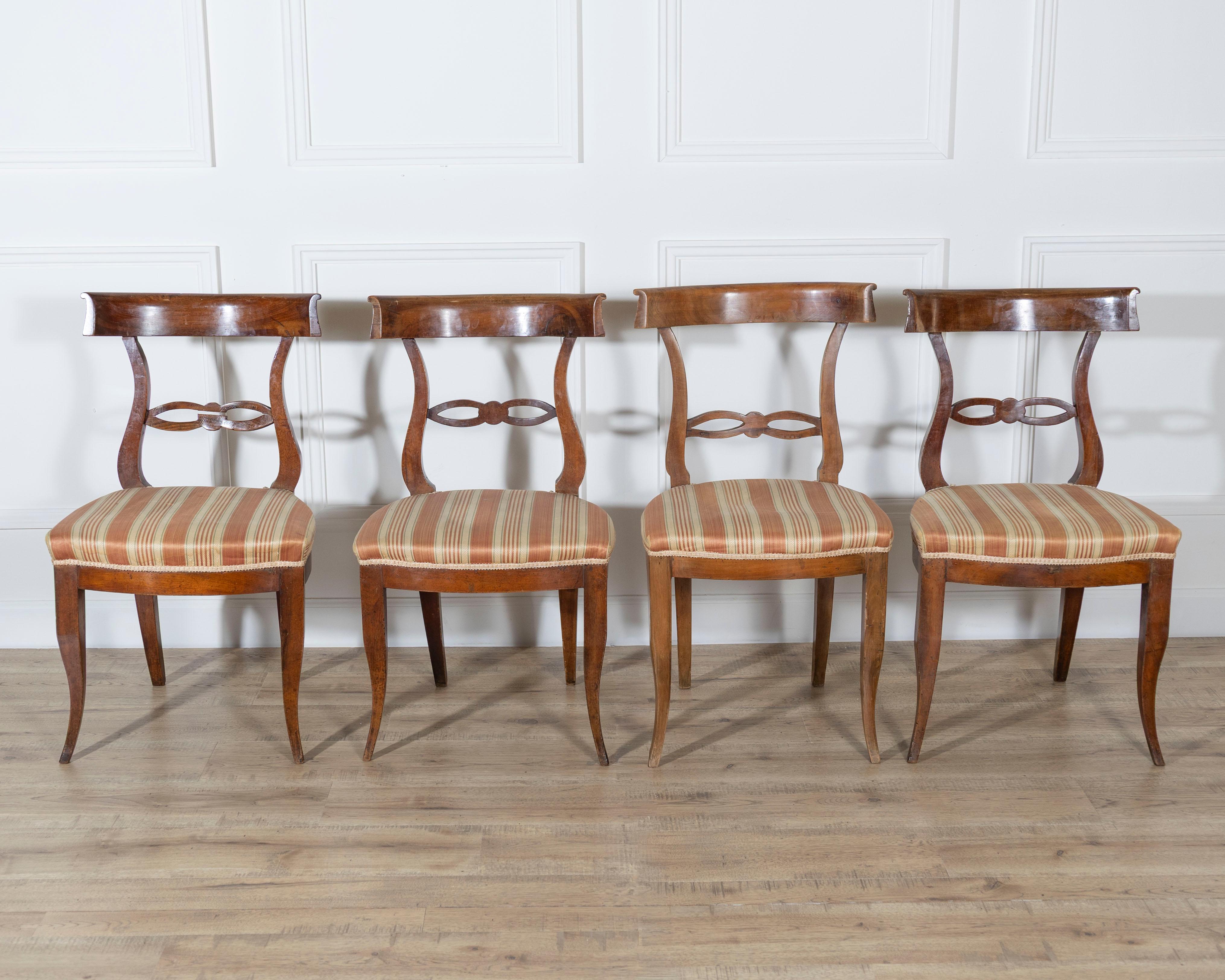 A refined set of four Tuscan chairs dating from the late 18th to early 19th century, beautifully crafted in solid walnut. Exemplifying the graceful simplicity of the Directoire period, each chair features an elegantly curved backrest with a carved