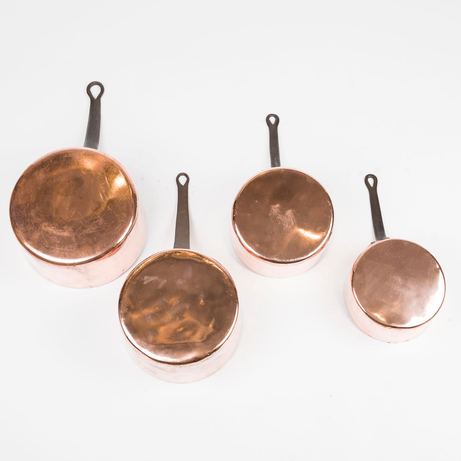 A set of four late 19th century French graduated good quality copper cooking pans with riveted iron handles. retaining some of their original interior tinning. 

The largest pan engraved with the initials F.G

The two smaller pans numbered 16 and