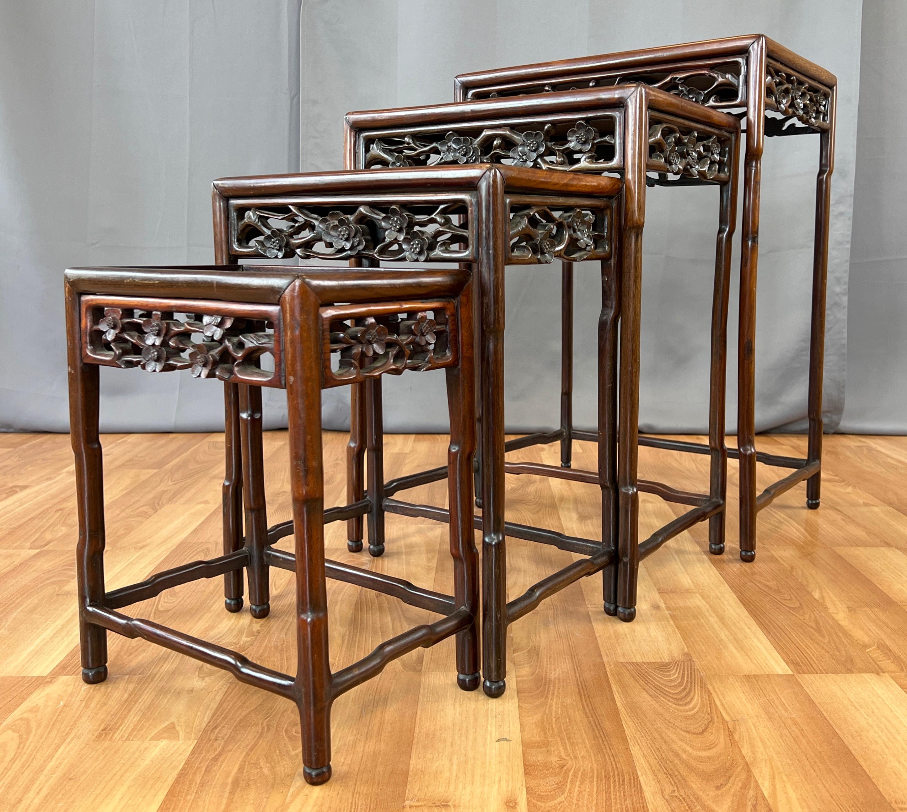 Offered here is a set of four circa late 19th century or early 20th century Chinese nesting tables made out of Zitan wood.
Carved and shaped legs, and their cross bars also, rise up to hold the table top panel. Tables apron on their three