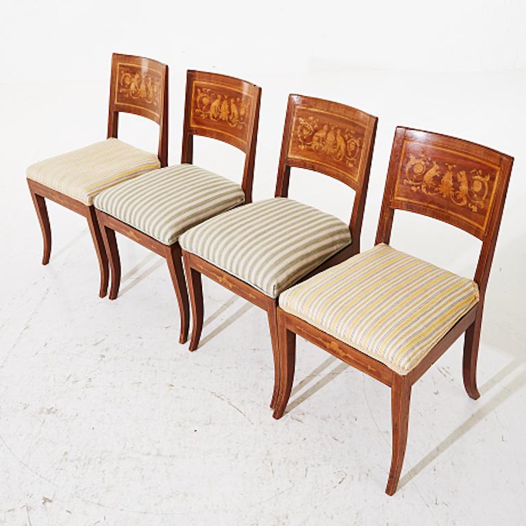 Set of four fabulous classical late-Empire chairs. Chairs contain depictions of Griffins on the back, 4 chairs in the set, late Empire, 1800s, mahogany, back tray with marquetry, seat height 48 cm.