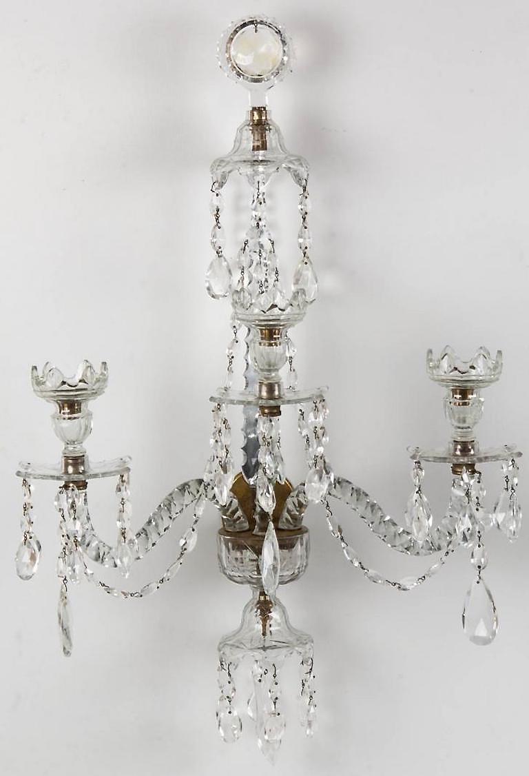 Adam style fine cut three-arm glass pair of wall fixtures / sconces, colorless, large circular faceted finial with a central hanging prism with a long zipper cut stem terminating in a brass seat which supports three curved arms holding matching cut