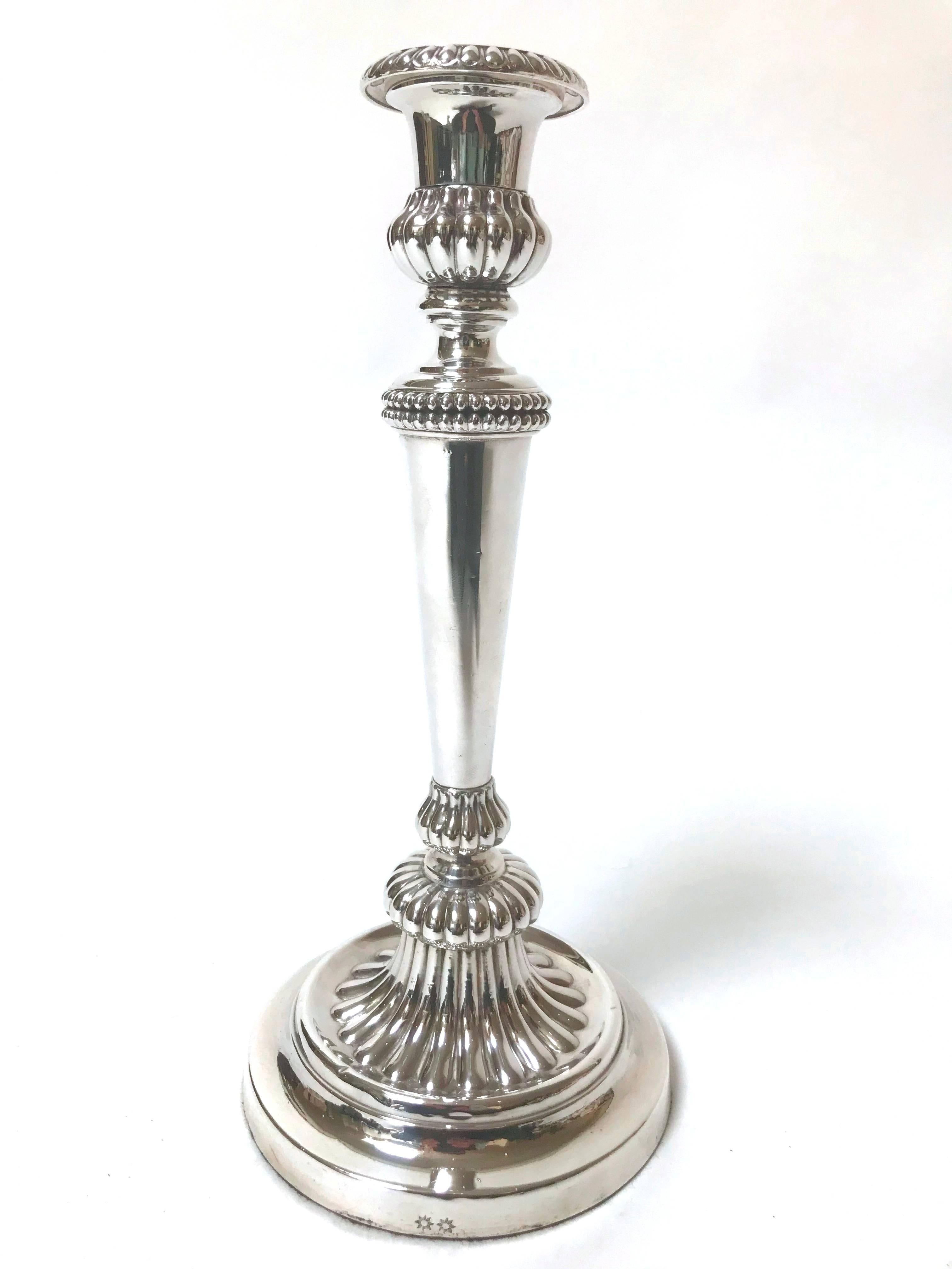 A rare set of four late George III plated silver candlesticks, circa 1790-1820, marked for Matthew Boulton, Birmingham, England. Marks: Double sunburst punch, 11-3/4 inches high, each having a tapered cylindrical standard rising from a circular