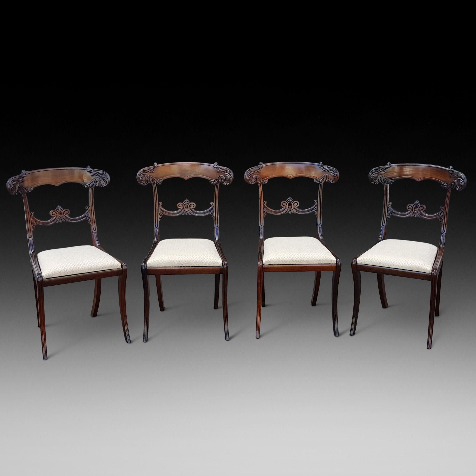 Set of four late Regency rosewood dining chairs with acanthus leaf carved to rail, scroll and anthemion bar and sabre legs front and back
Measures: 18