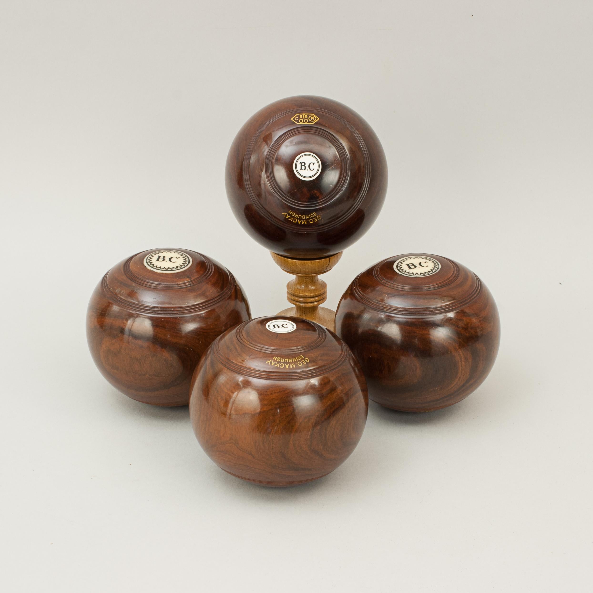 Lawn bowls, George Mackay, Edinburgh.
A set of four lignum vitae lawn bowls by 'George Mackay, Blackfriars Street, Edinburgh'. The bowls have discs on both ends with initials 'B.C'. The bowls are stamped in gilt writing 'Geo.Mackay' with the