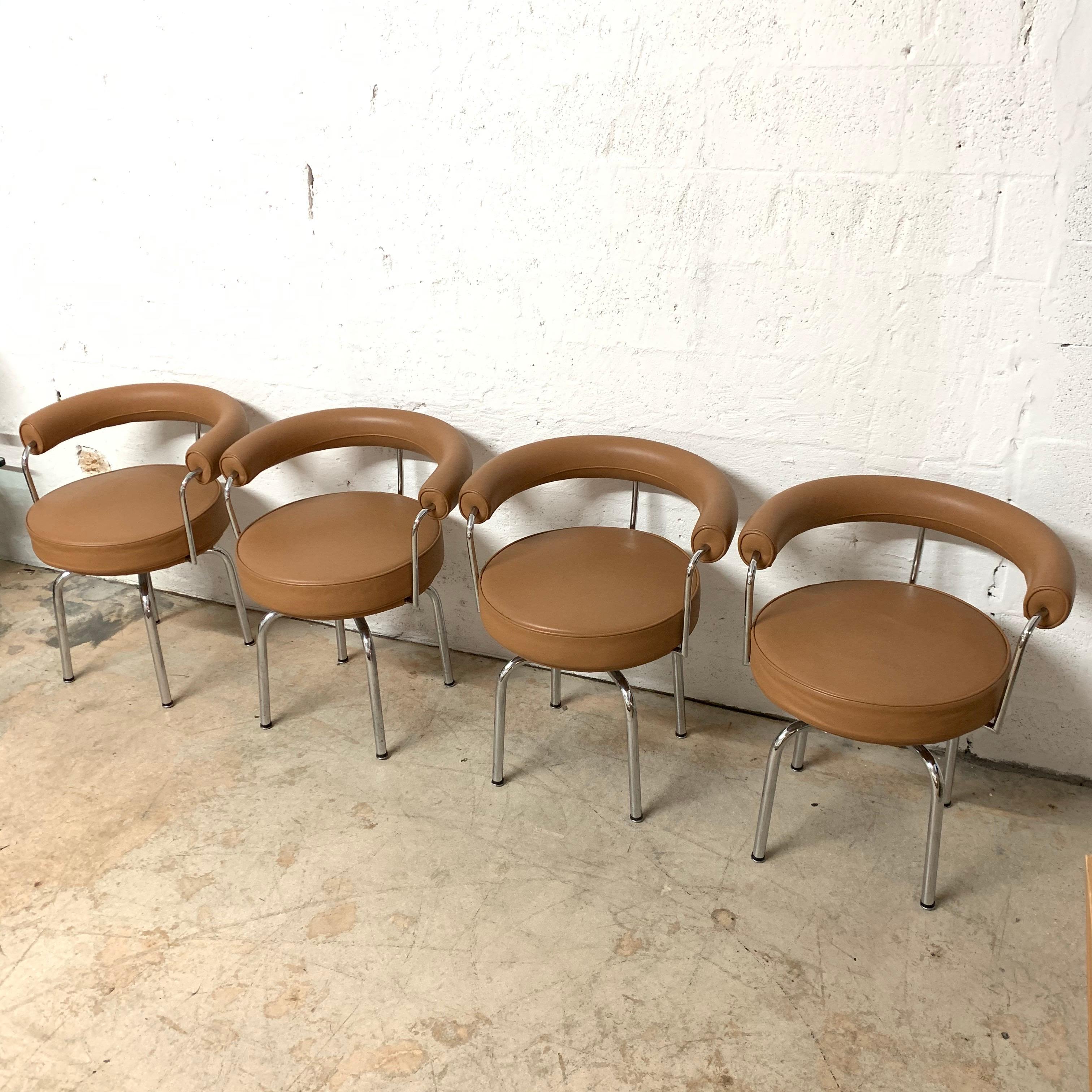 Set of four LC7 swivel dining chairs rendered in a chrome-plated steel frame with cognac leather upholstery designed by Le Corbusier, Charlotte Perriand, and Pierre Jeanneret for Cassina, Italy, 1970s.