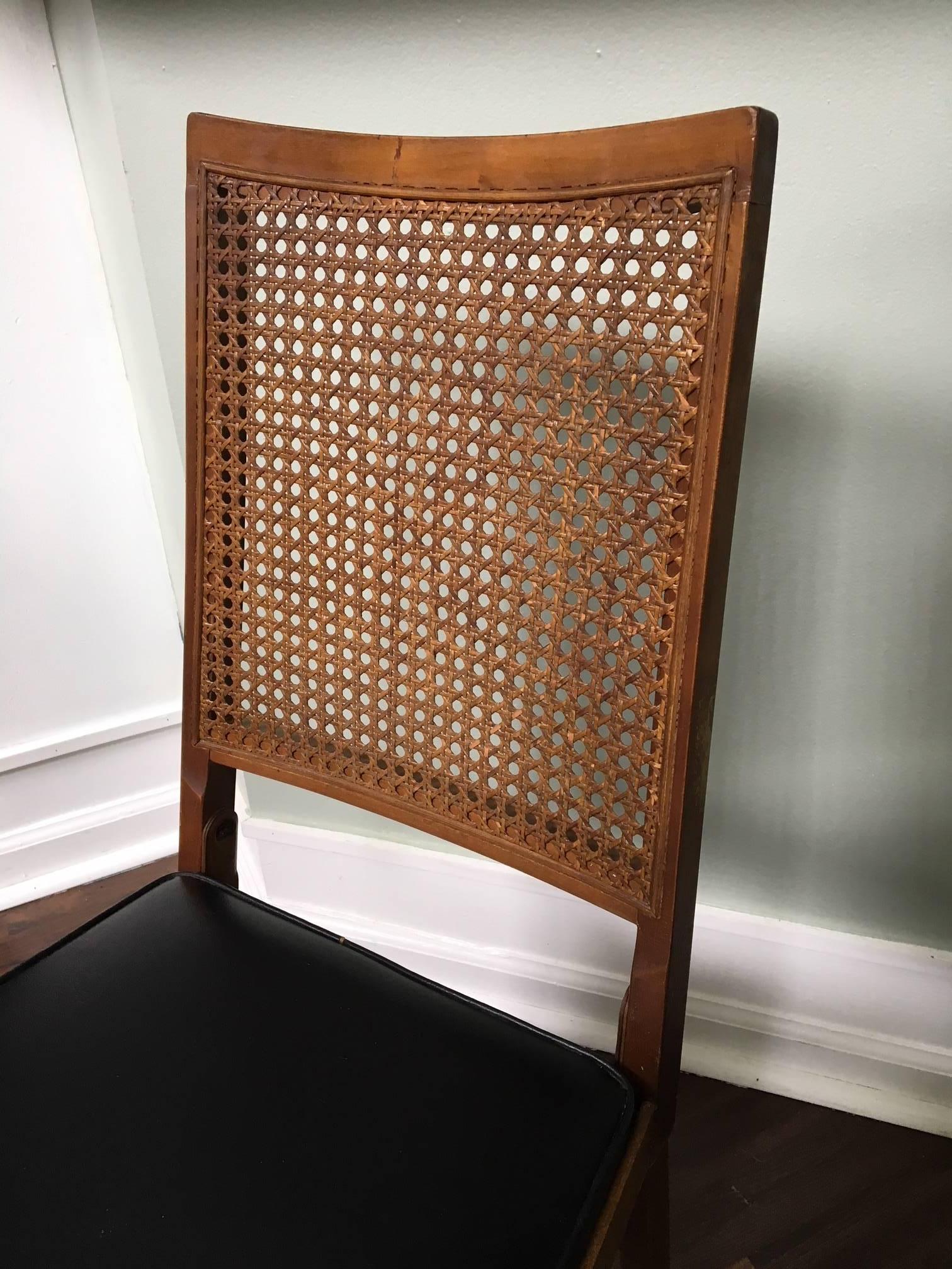 Ein Satz von vier Leg-O-Matic-Klappstühlen im Vintage-Stil mit Rückenlehnen aus Schilfrohr und Sitzen aus Kunstleder. Sie wurden von Lorraine Industries in Bridgeport:: CT:: gebaut und wegen ihrer kompakten Bauweise sowohl über Sears and Roebuck als