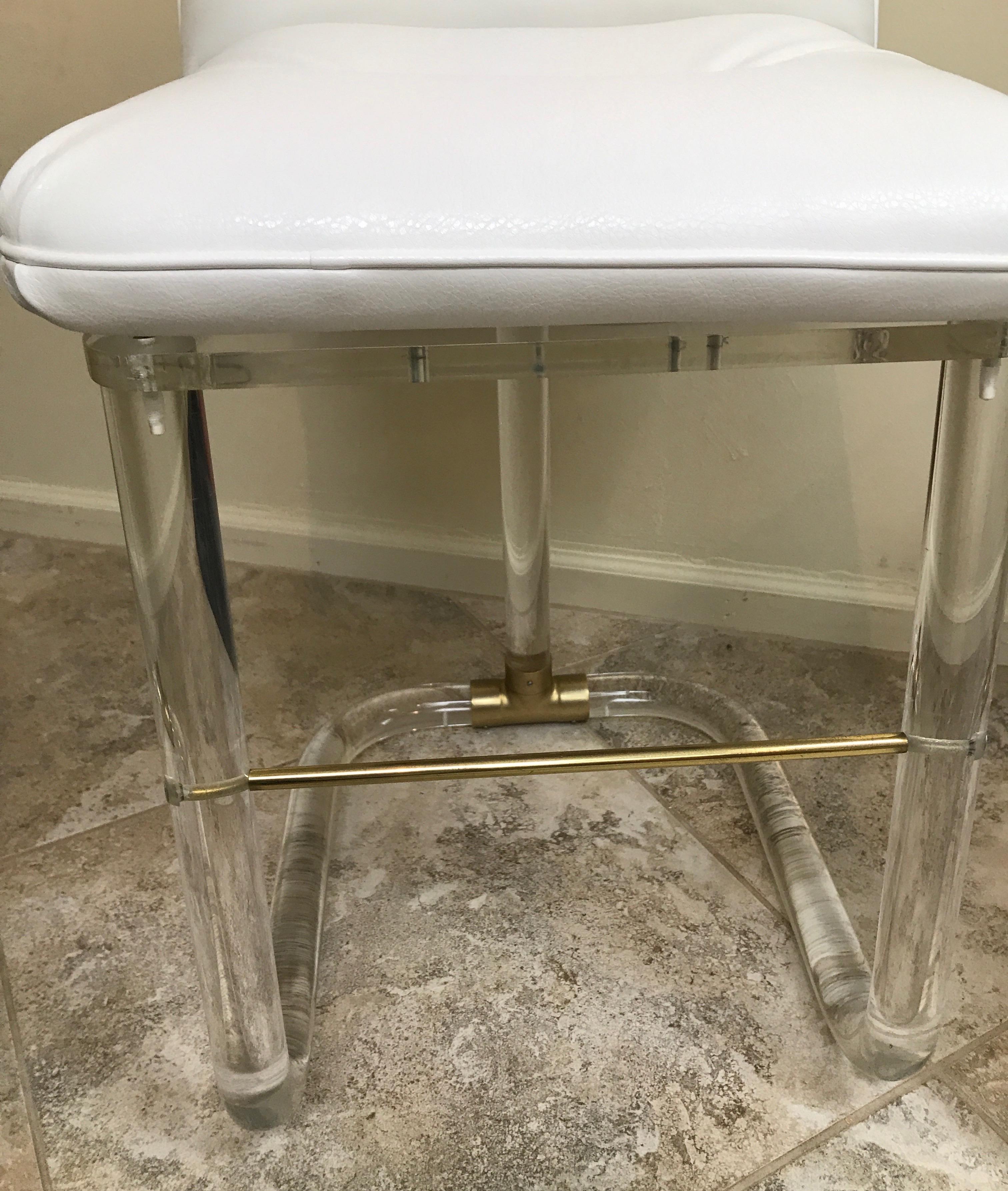 Four Lucite swivel counter stools with newly upholstered seats by Lion in Frost. Each stool signed on back near bottom.