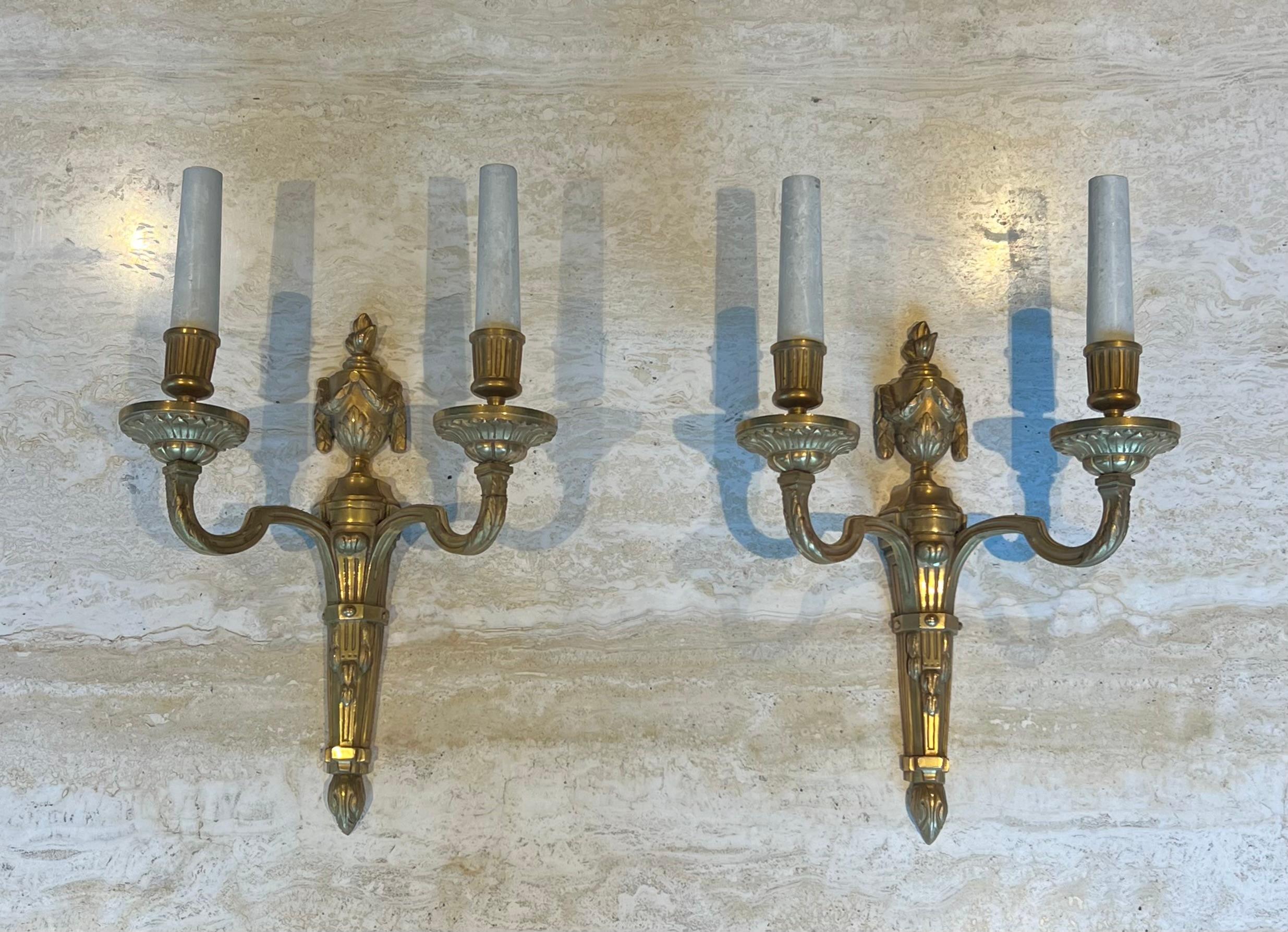 Ce très bel ensemble de quatre appliques murales est en bronze ciselé. Il s'agit d'une œuvre française dans le style de Louis XVI. Circa 1940