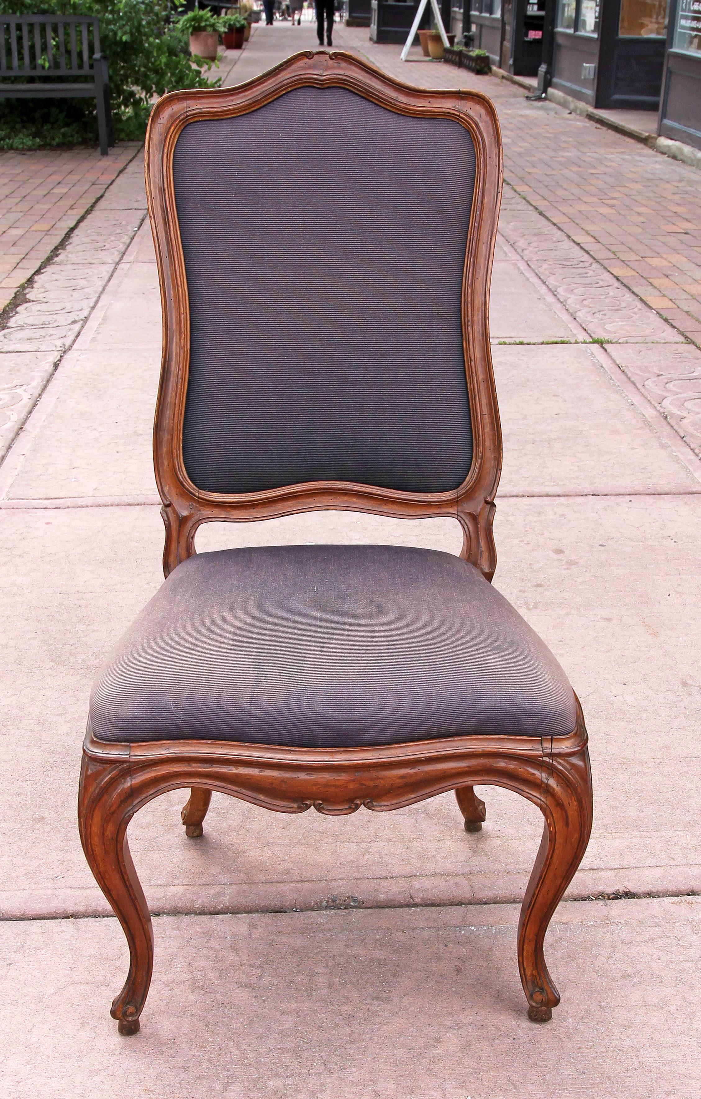 Set of four period Louis XV side chairs. Carved hardwood with pinned mortise and tenon construction. Good old finish. Chairs need tuning up. Two of the chairs need some of the joints tightened and upholstery needs to be replaced. We have priced