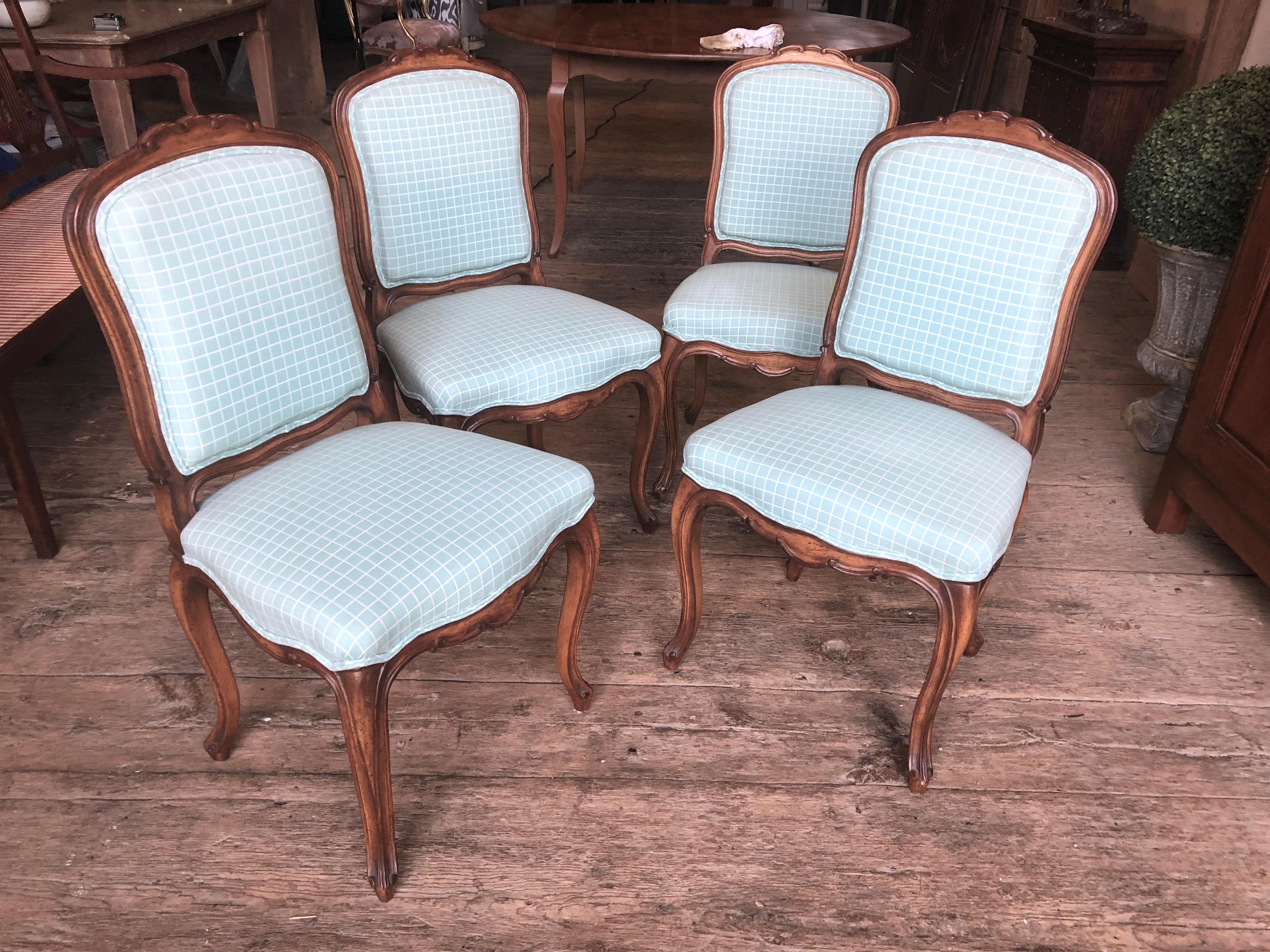 A nice set of four Louis XV style side chairs upholstered in blue and white check cotton fabric. The frames are good scale and nicely hand carved beech wood. Stained a medium cherry. Scalloped aprons and cabriole legs. These are high quality