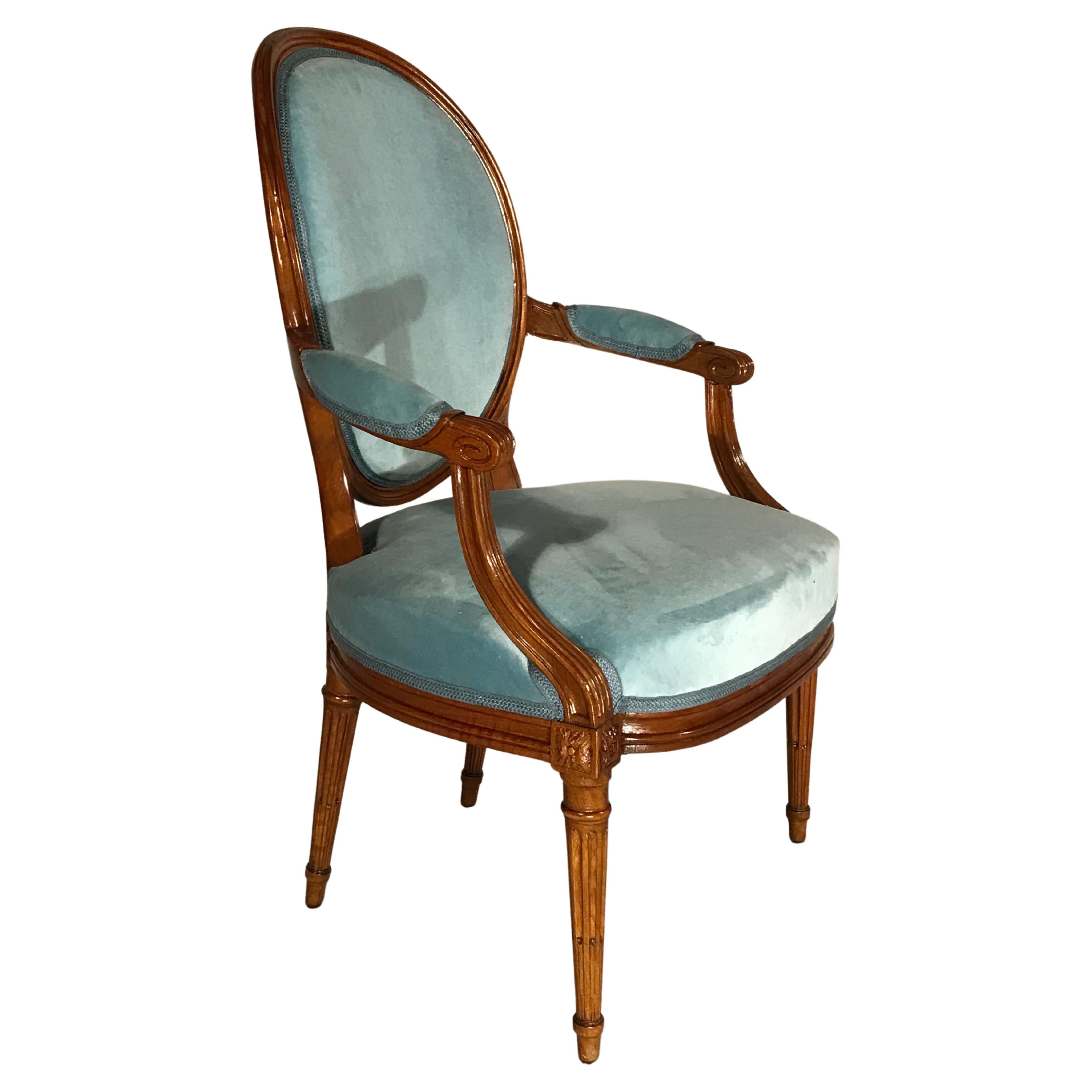 This set of four original Louis XVI armchairs dates back to around 1830 and comes from France. The elegant armchairs have an oval shaped backrest, The four fluted legs are connected to the slightly curved armrests. The chairs have beautifully carved